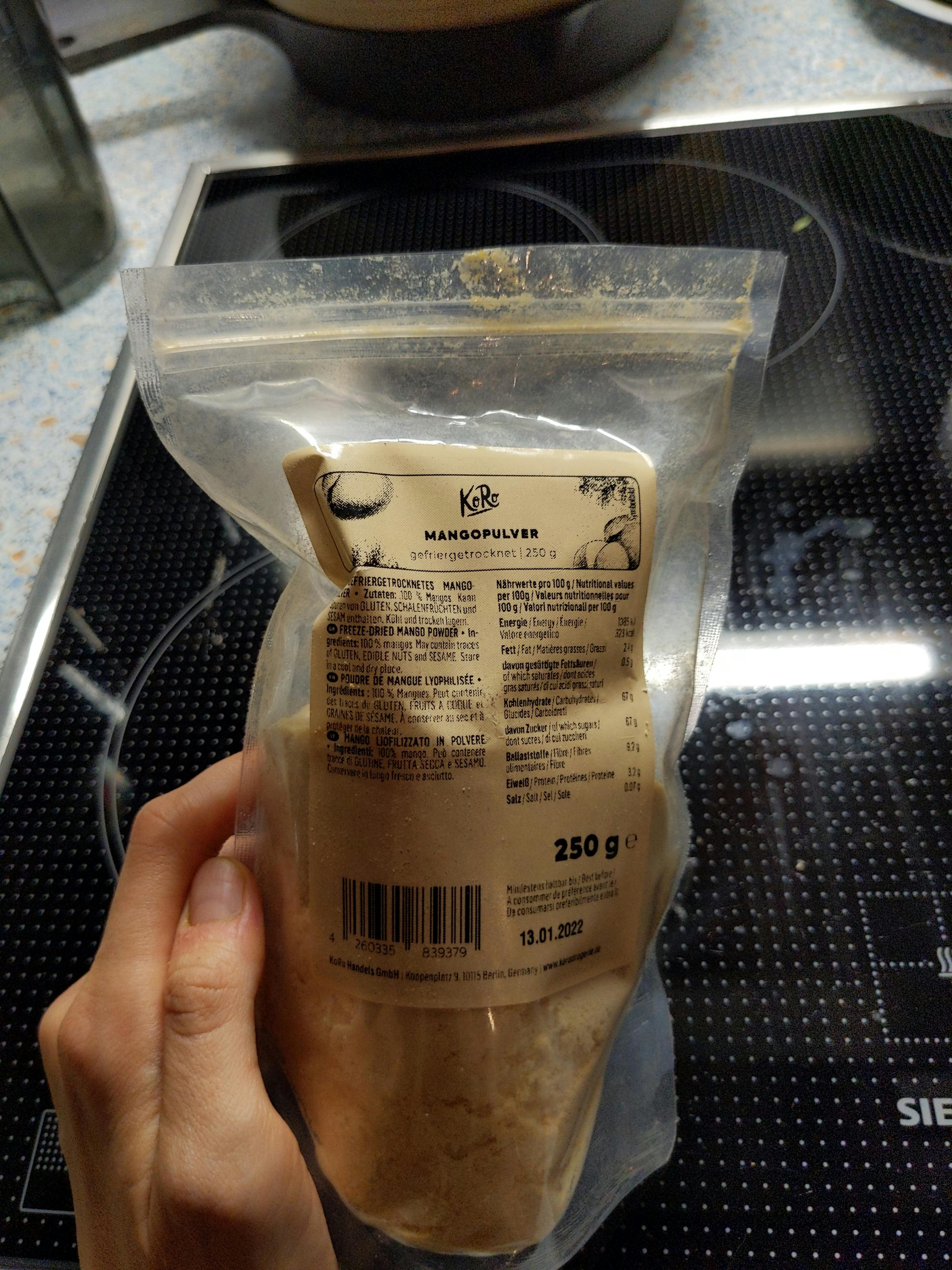 eine Person hält eine Tüte mangopulver in ihren Händen