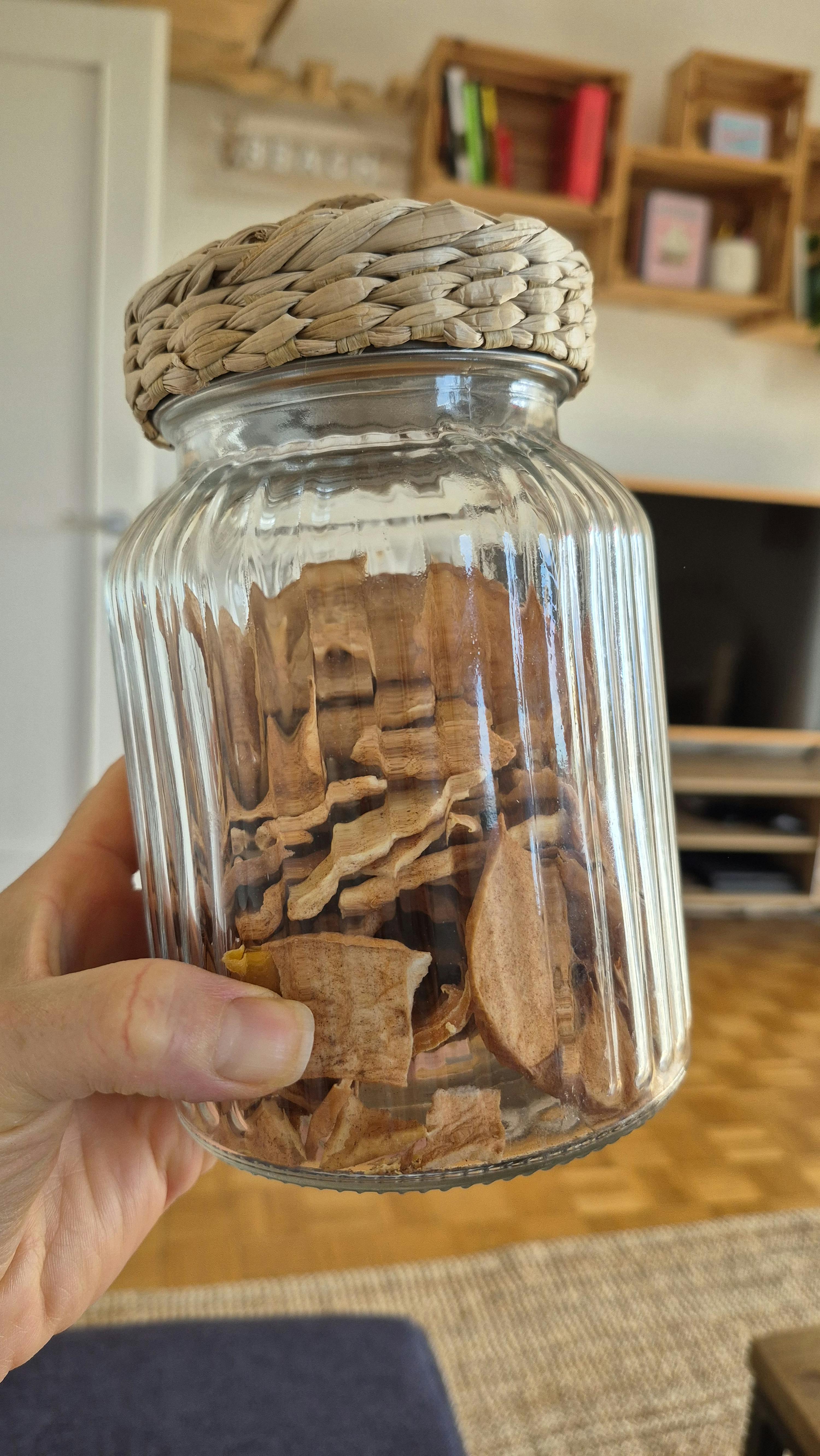 una persona tiene in mano un barattolo di vetro pieno di biscotti