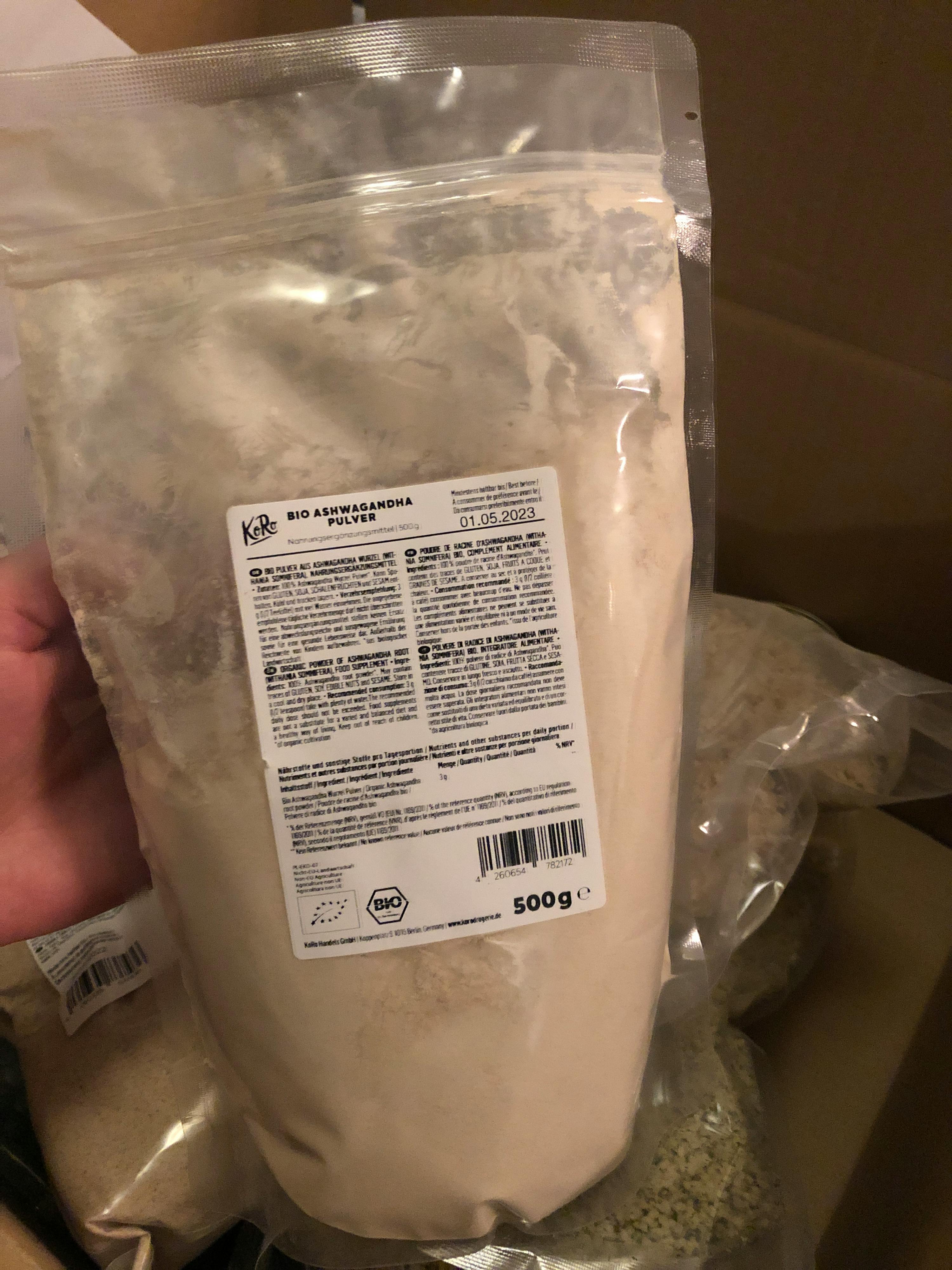 una persona tiene in mano un sacchetto di farina di ashwagandha