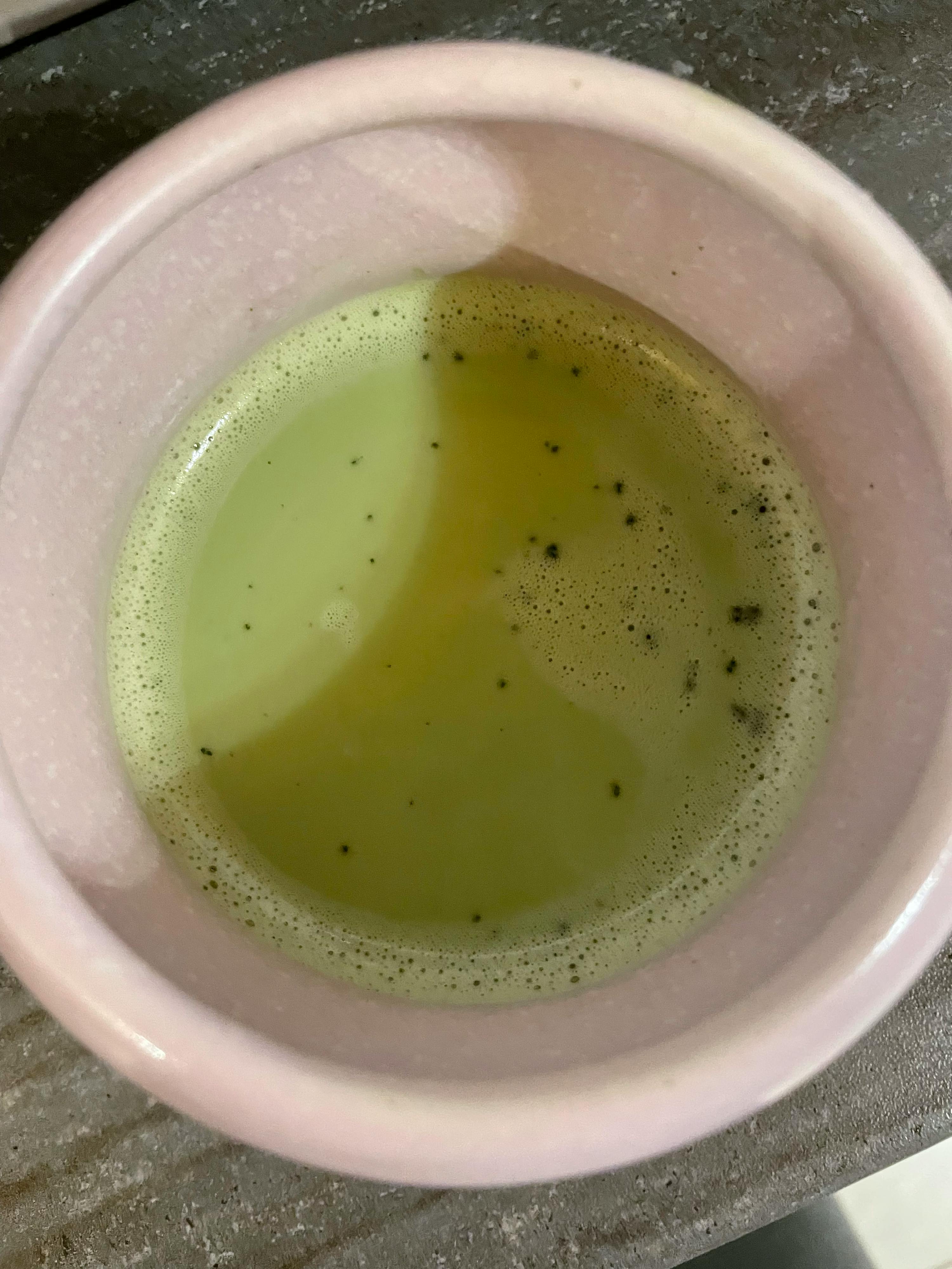 a pink bowl filled with green liquid with bubbles