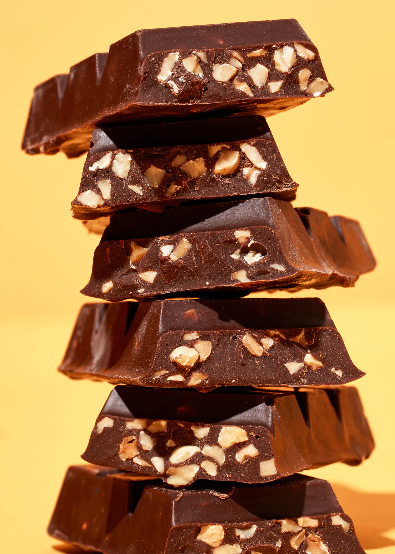 des morceaux de chocolat sont empilés les uns sur les autres sur un fond jaune