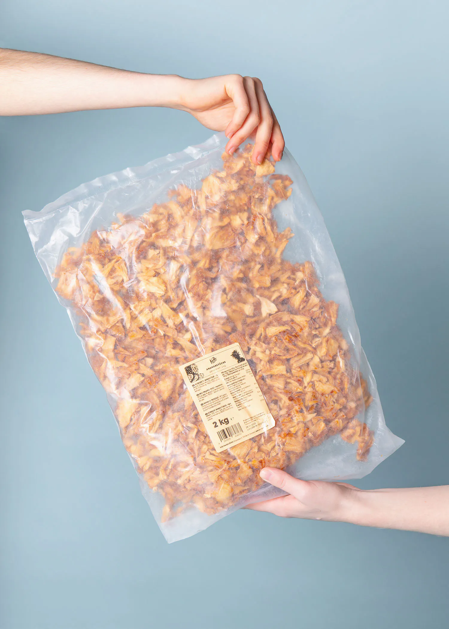 zwei Hände halten einen Plastiksack mit einem Etikett auf der Rückseite