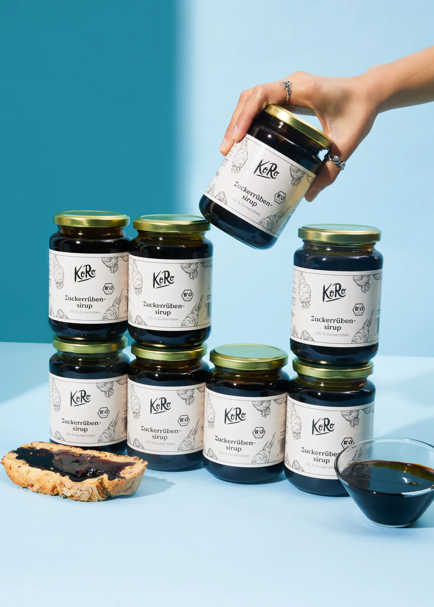 a person is holding a jar of zuckerrohren sirup