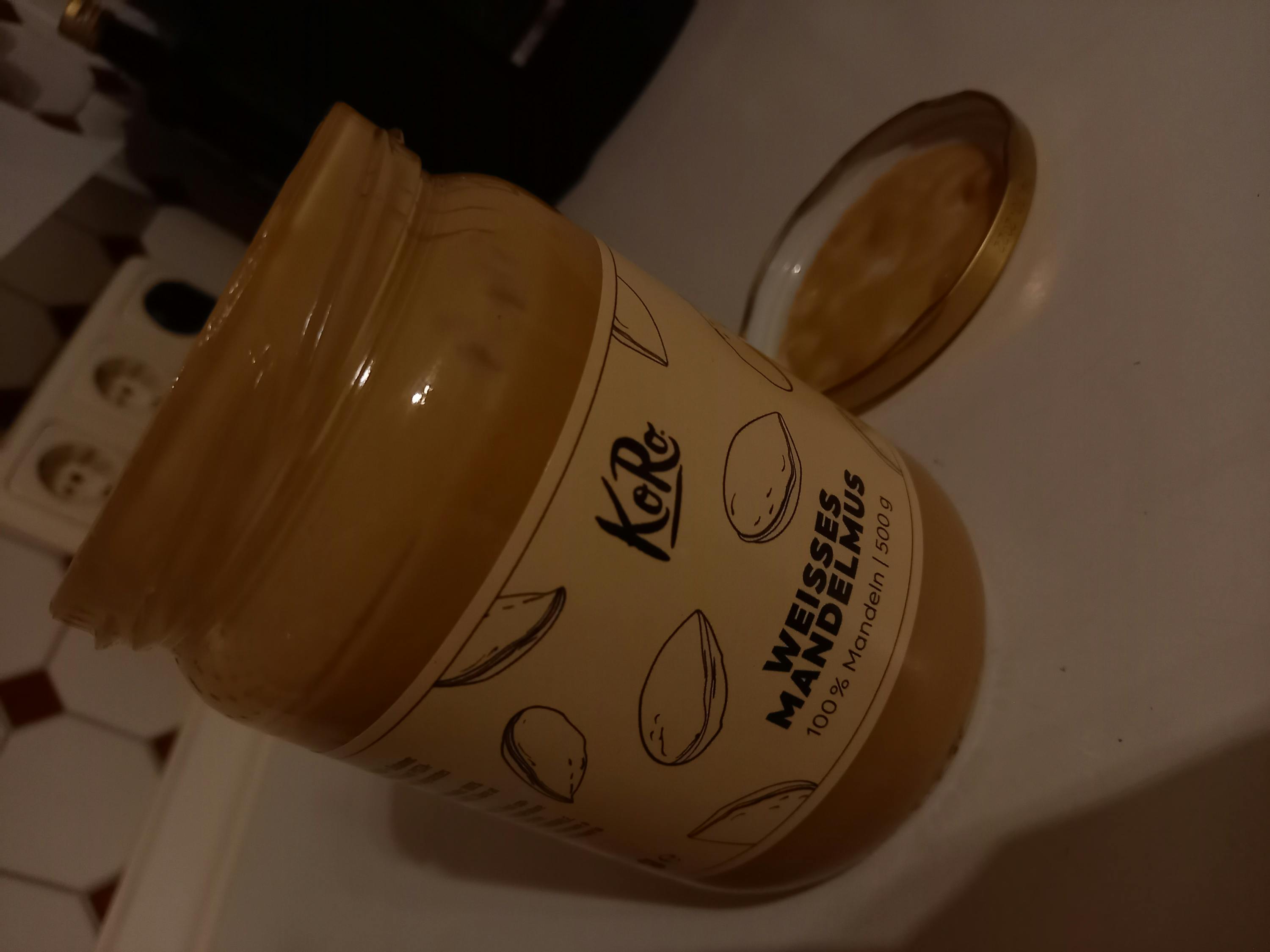 un barattolo di burro d' arachidi bianco con il coperchio aperto