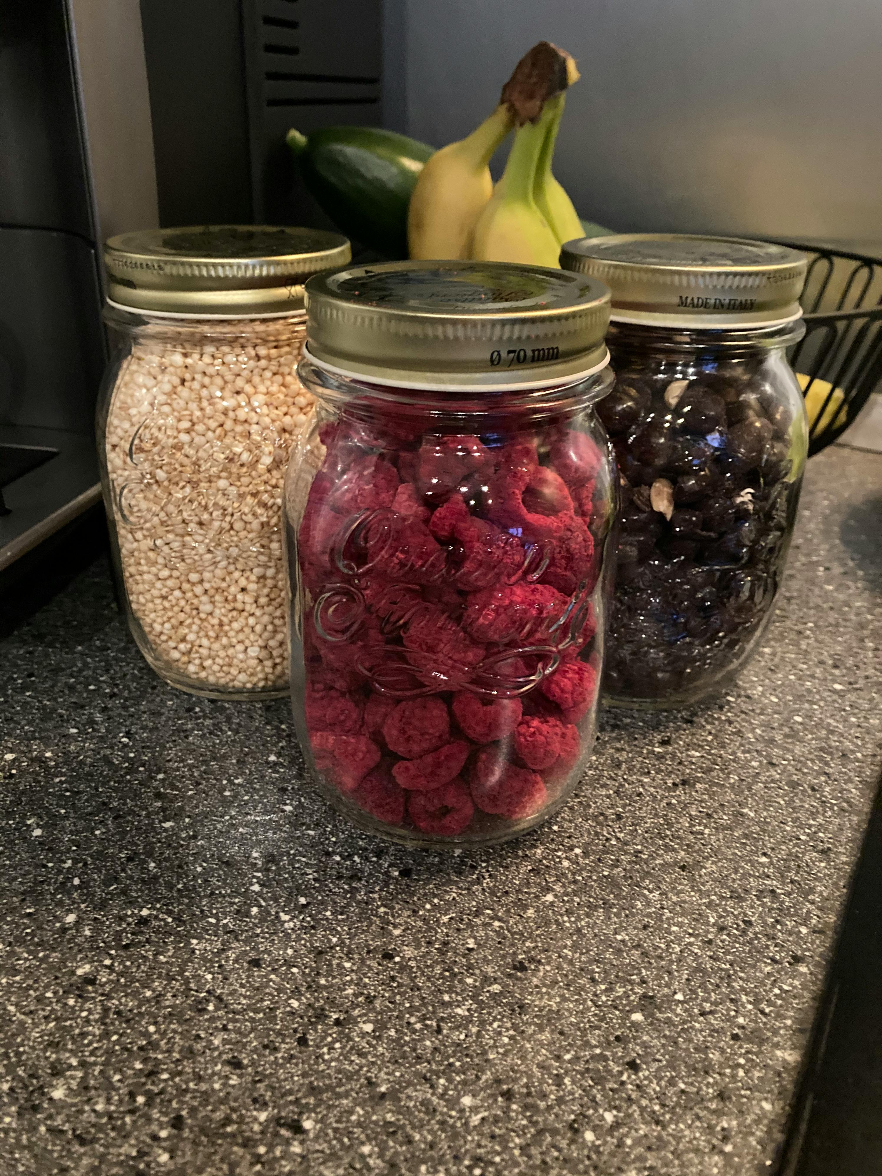 three mason jars filled with different types of fruit and grains