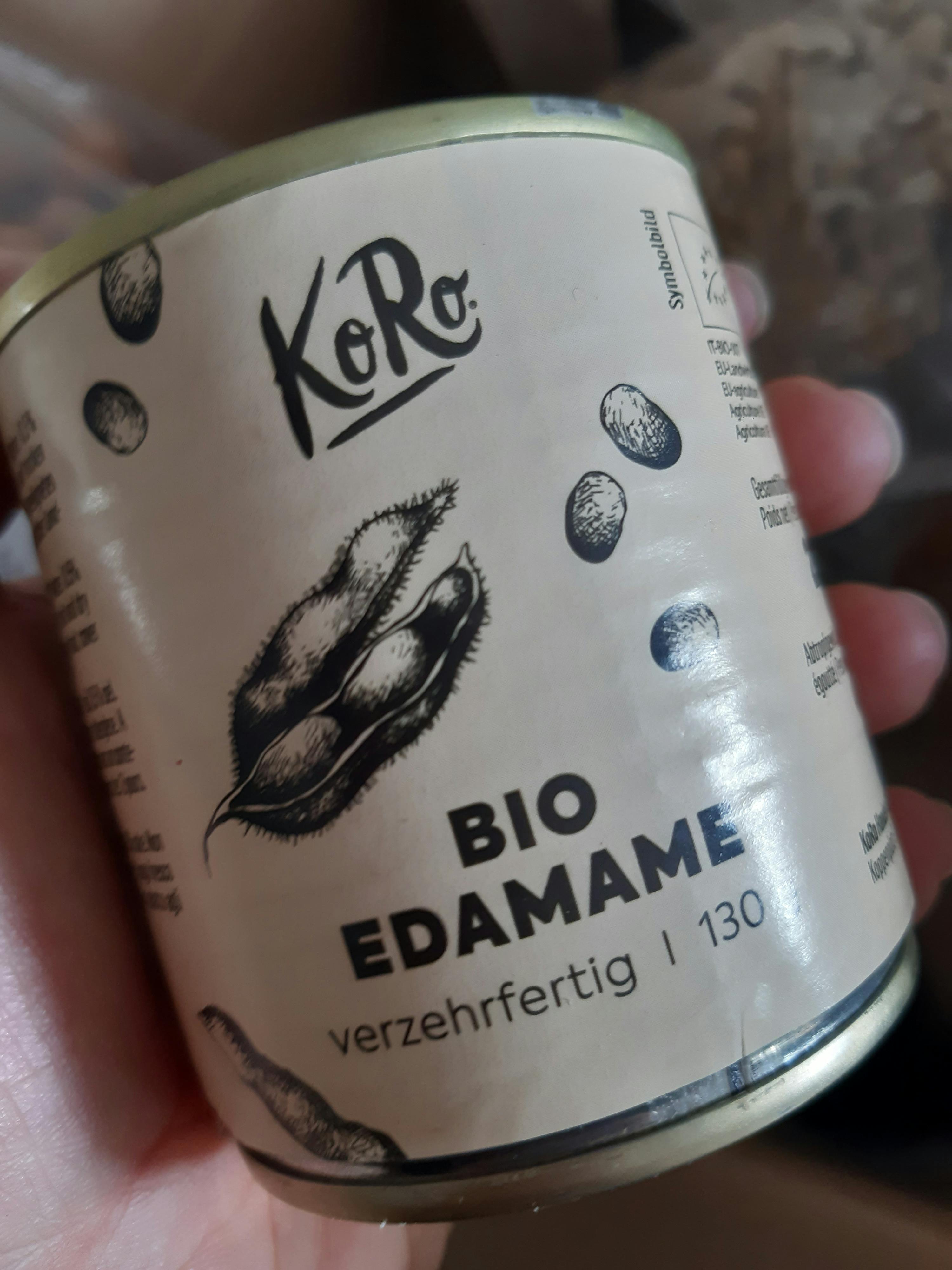 a person is holding a can of bio edamame in their hand