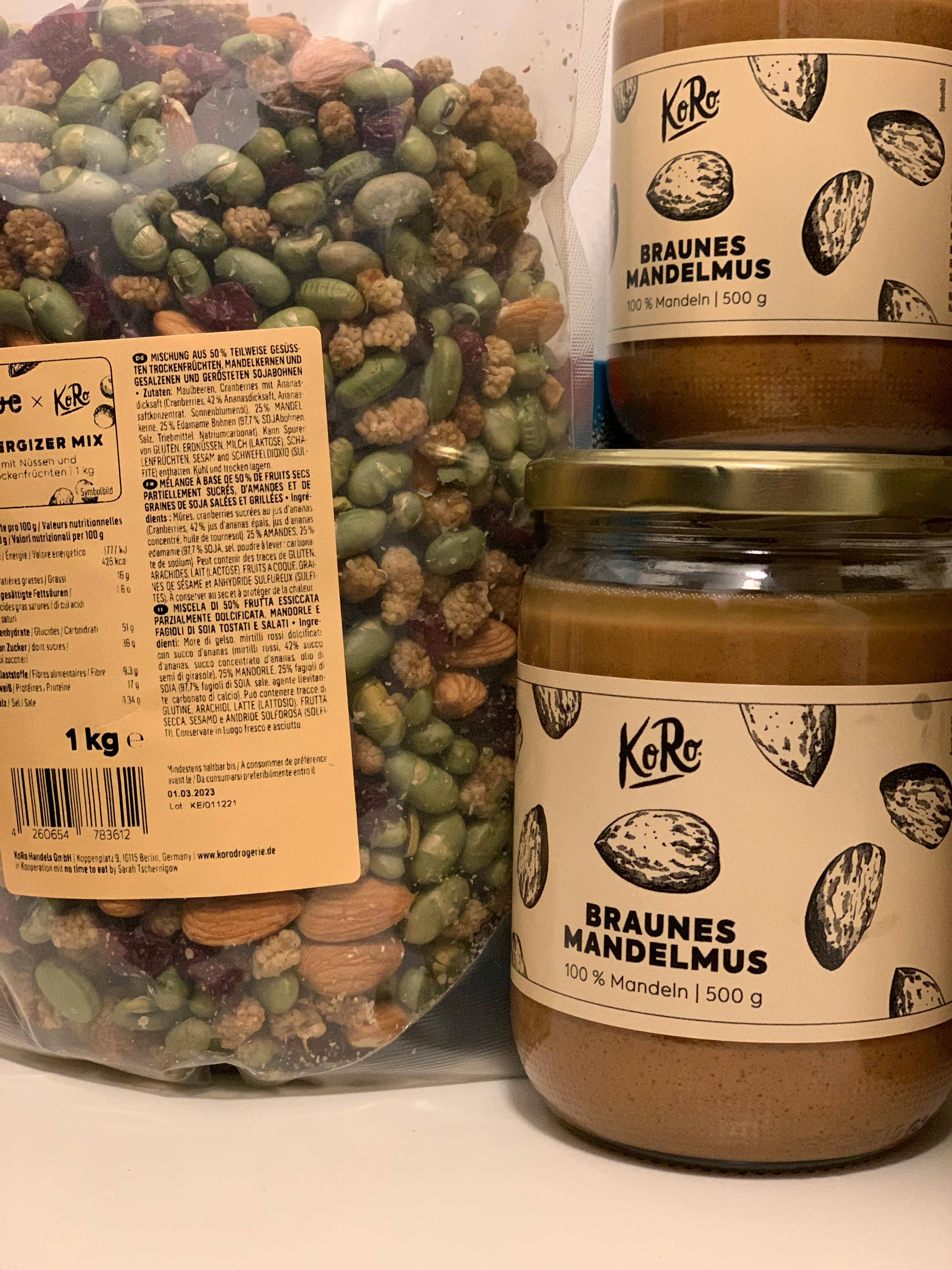 a jar of braunes mandelmus sits next to a bag of nuts