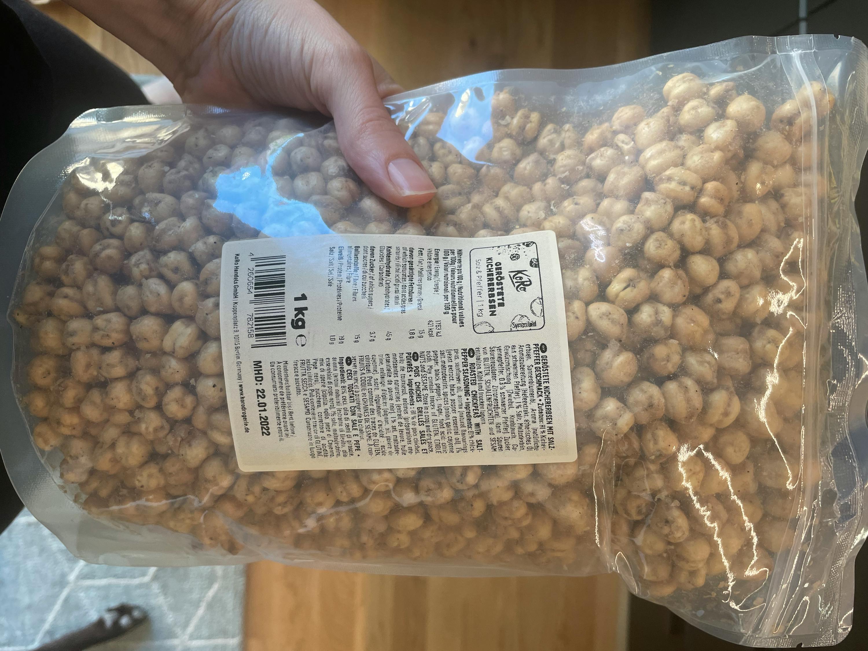 eine Person hält eine Tüte Haselnüsse in ihrer Hand