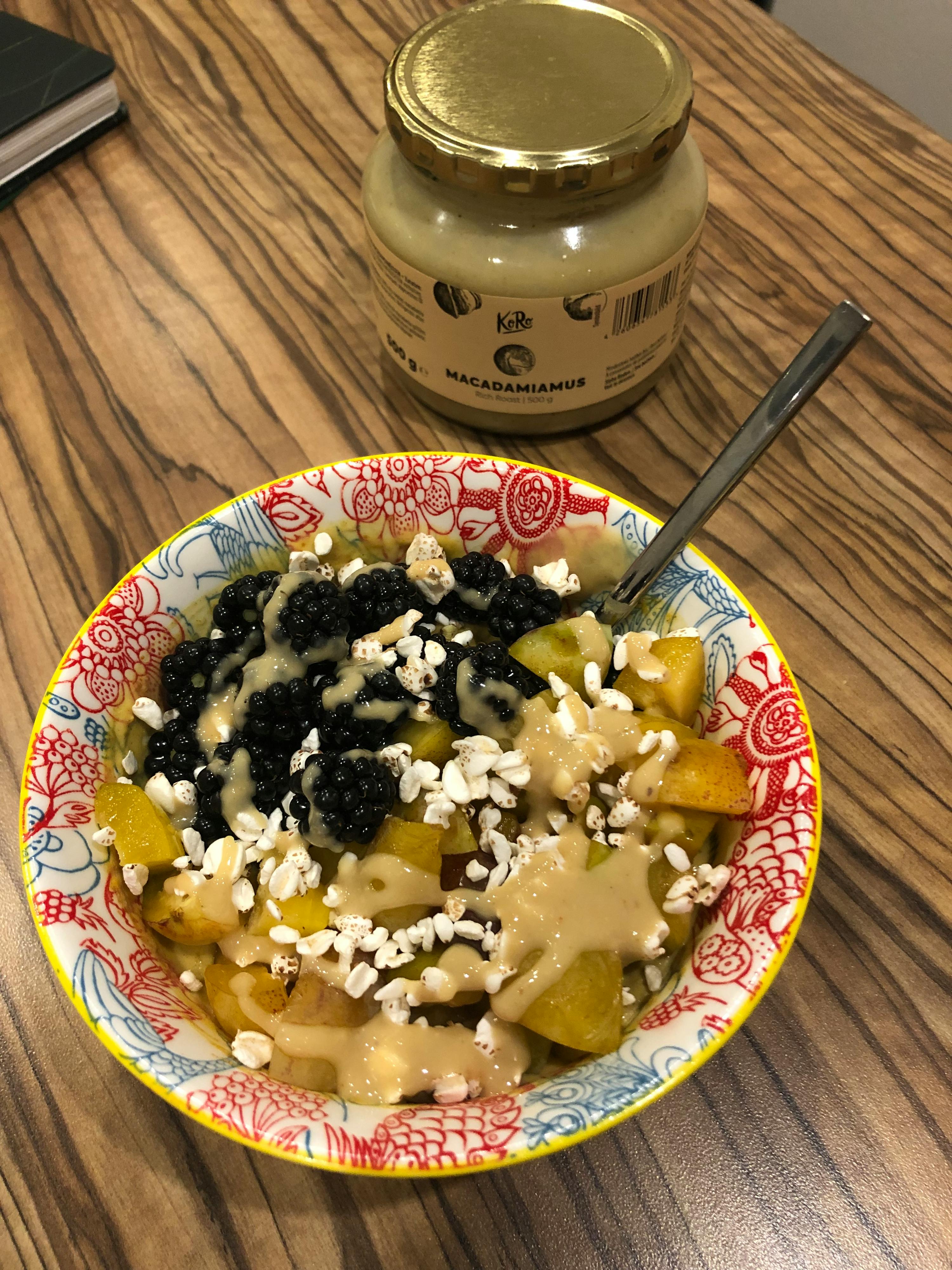 un barattolo di olio di macadamia è accanto a una ciotola di cibo su un tavolo di legno