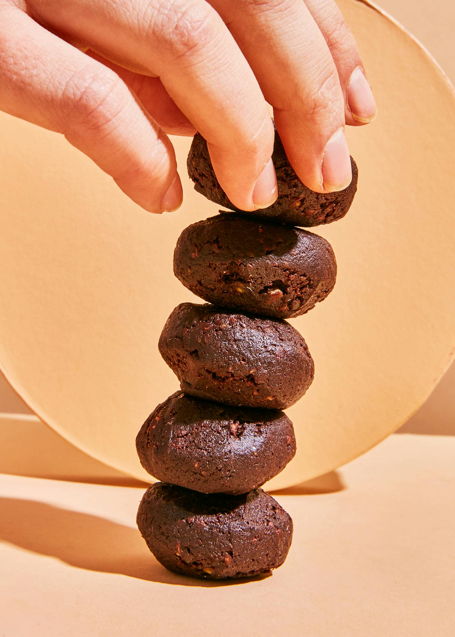 Eine Person stapelt Schokoladenkekse aufeinander