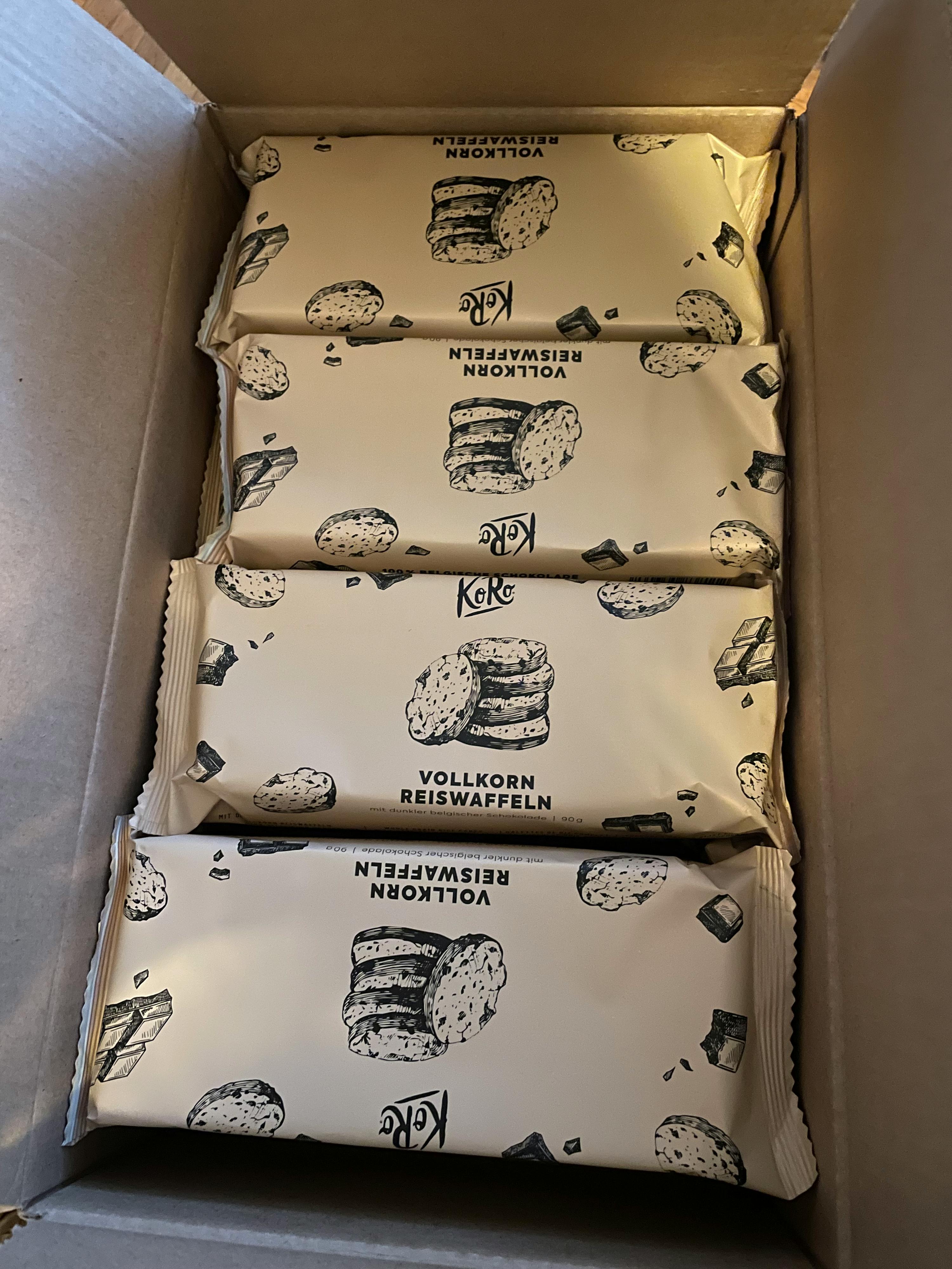 several packages of vollkorn reiswaffeln sit in a cardboard box