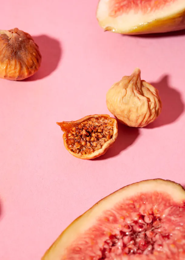 figs on a pink background with one cut in half
