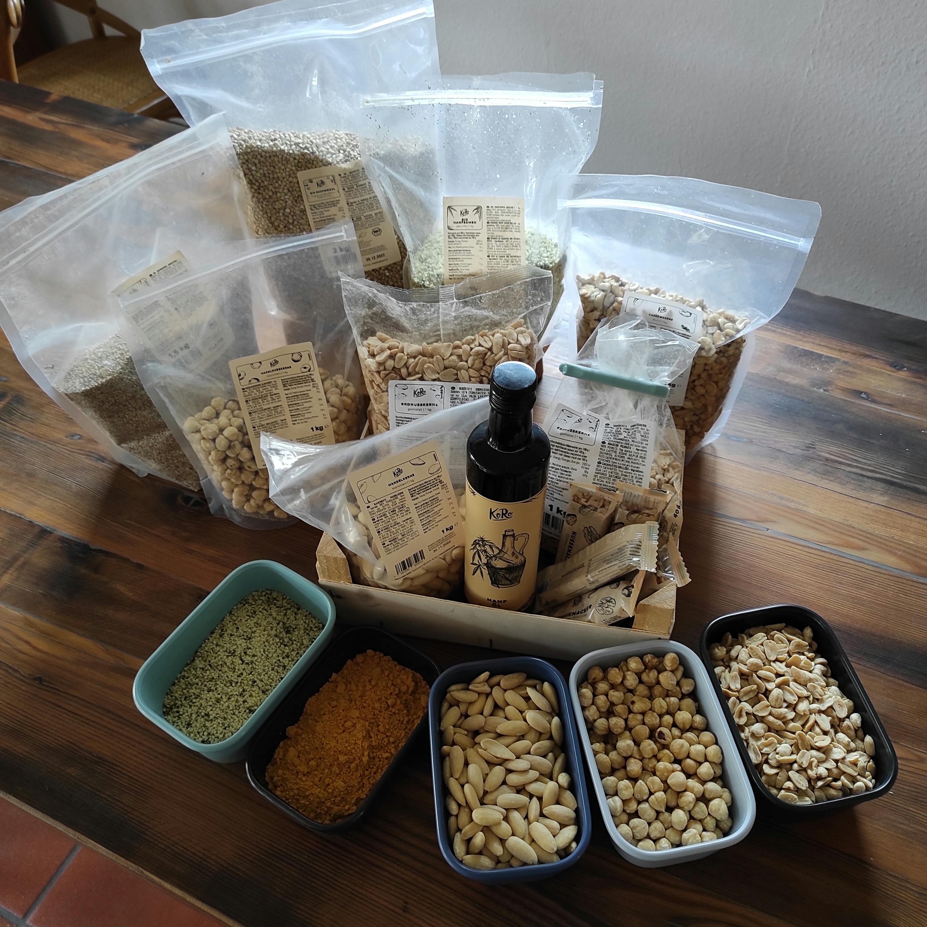 una bottiglia di olio è seduta accanto a una scatola di semi e noci