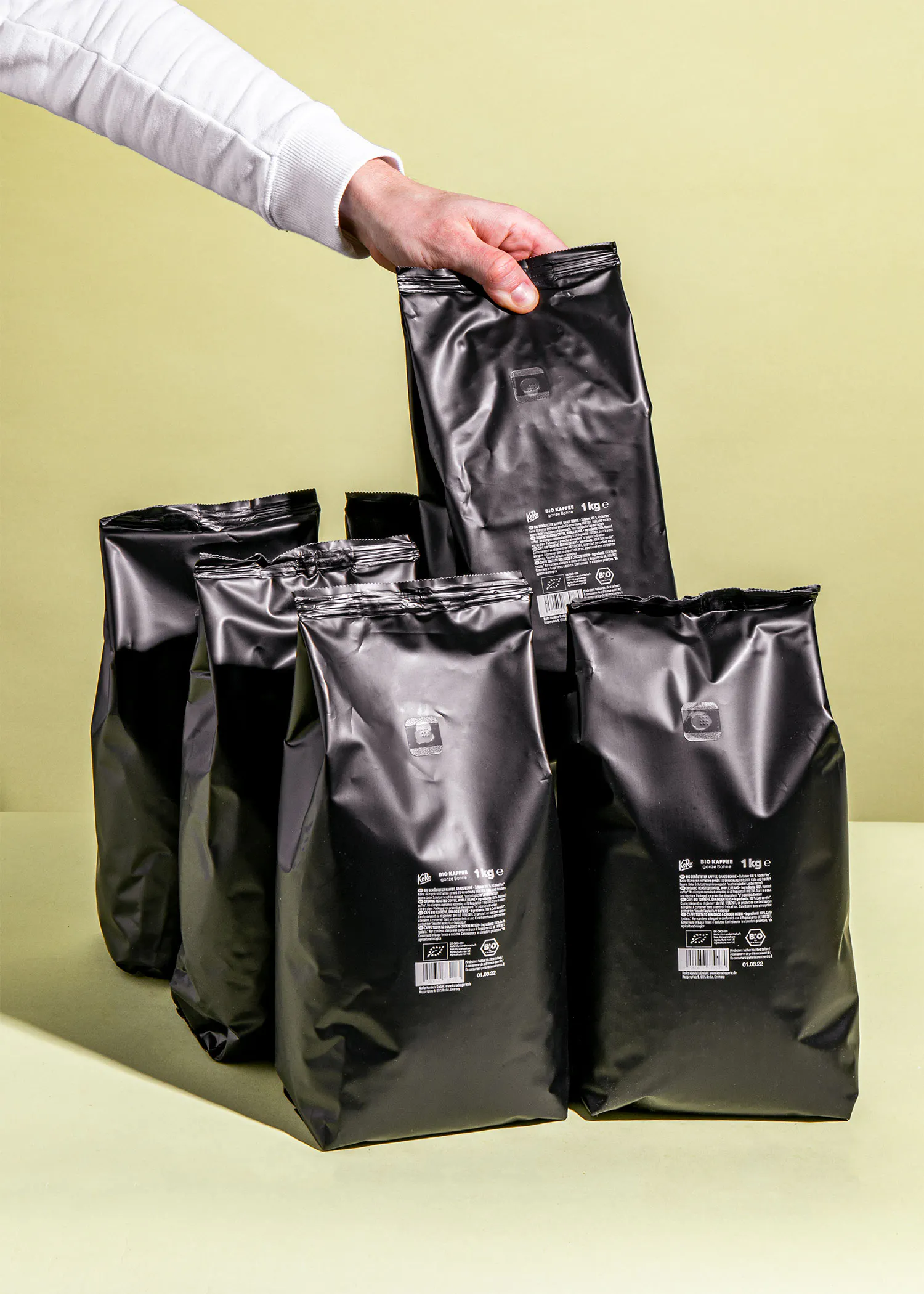 eine Person nimmt einen schwarzen Plastikbeutel mit einem Etikett aus einem Haufen schwarzer Taschen