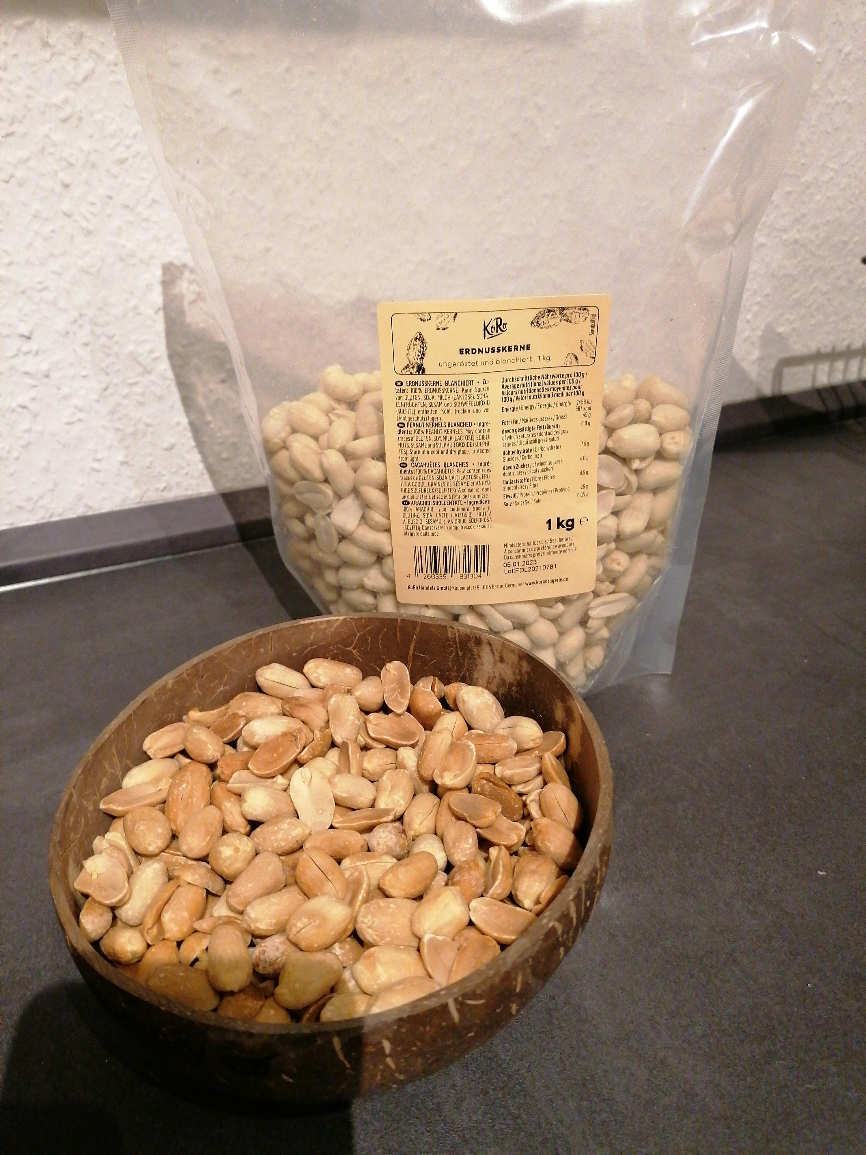 eine Tüte Erdnüsse neben einer Schüssel Erdnüsse