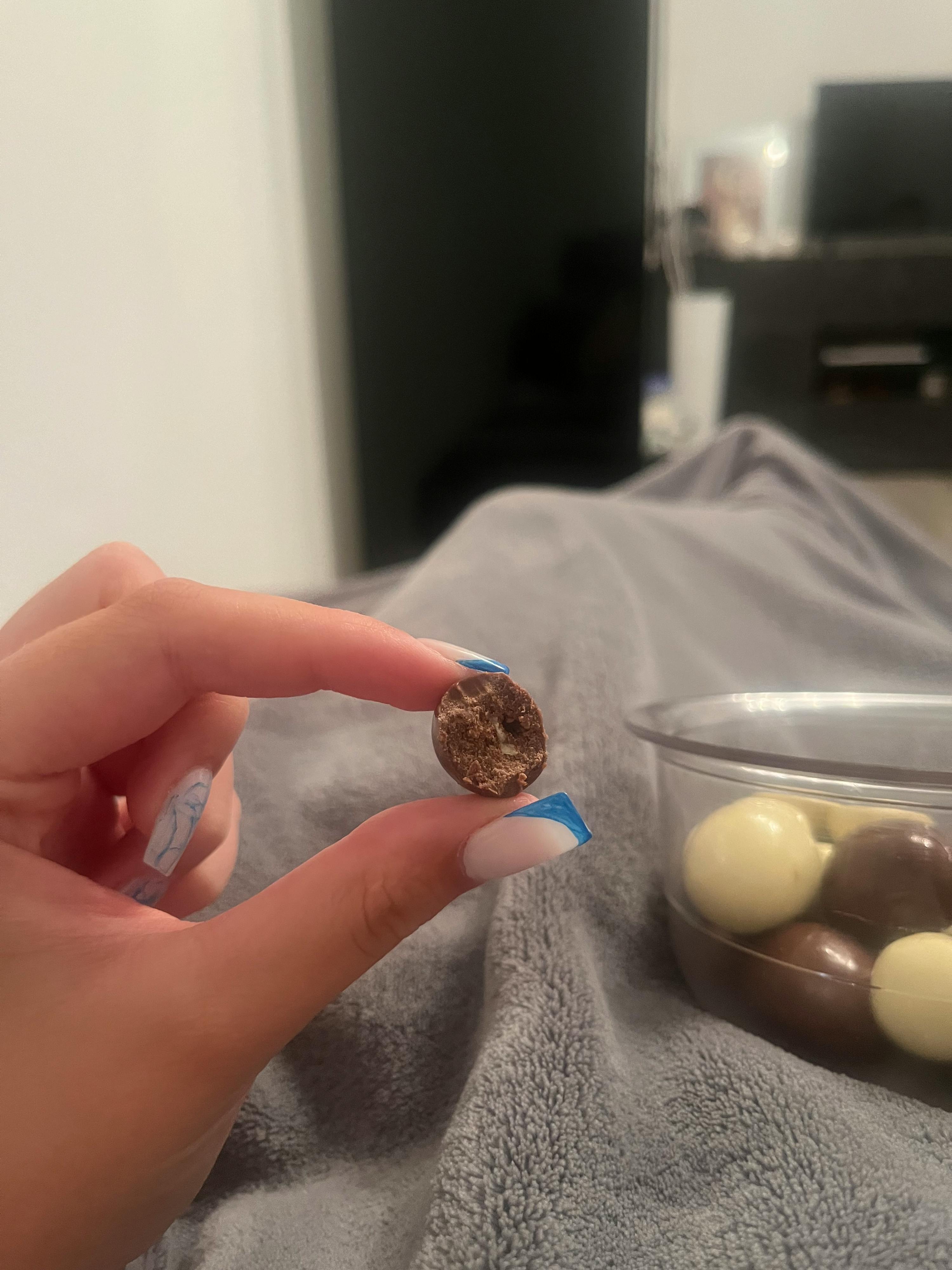 a woman holds a piece of chocolate in her hand