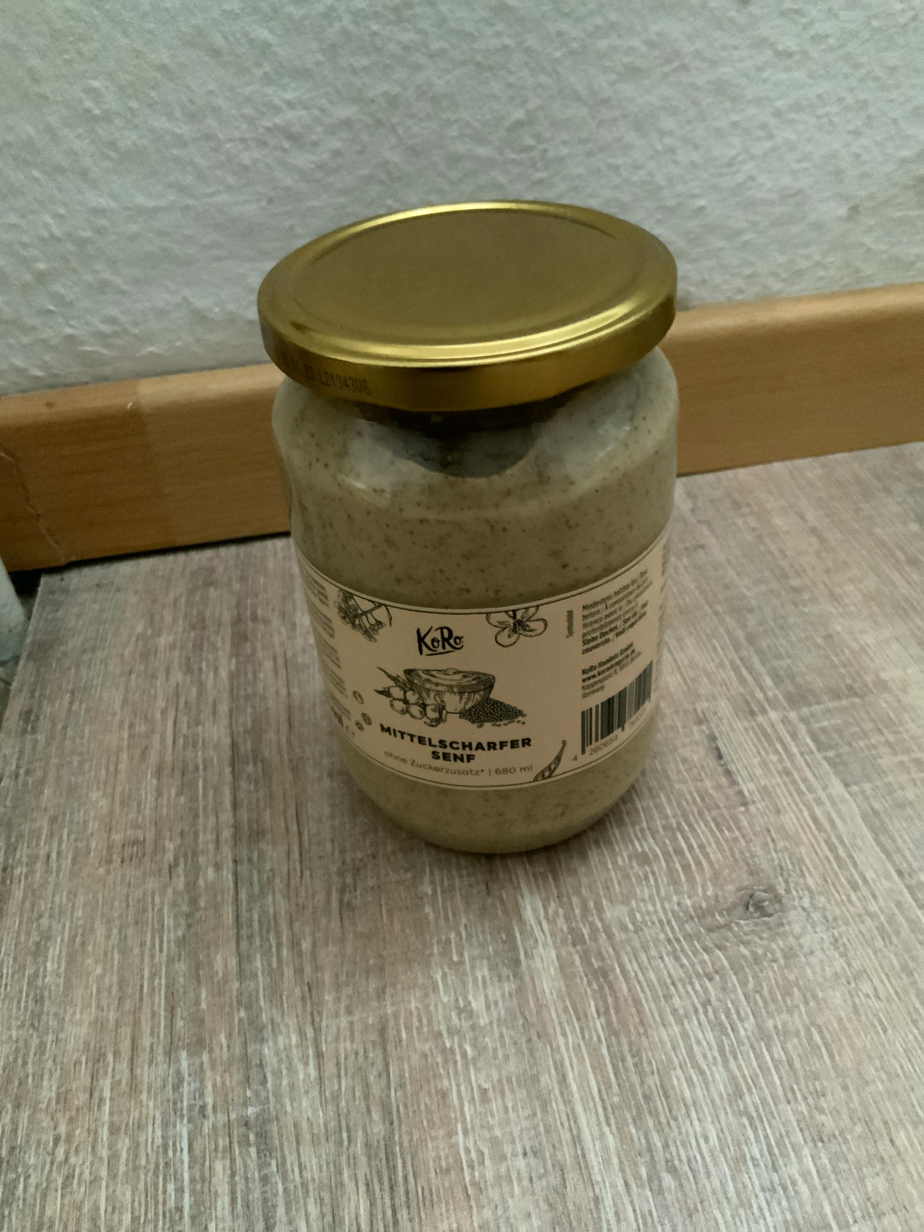 un barattolo di condimento è seduto su un tavolo di legno