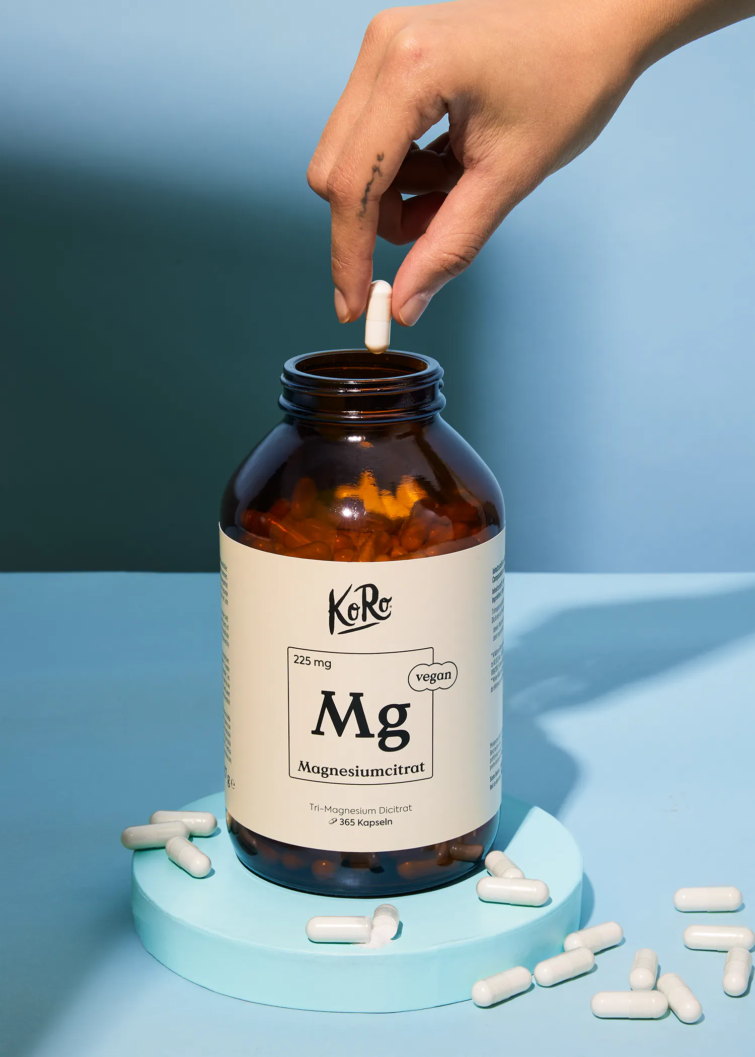 a person is taking a magnesium capsule out of a bottle