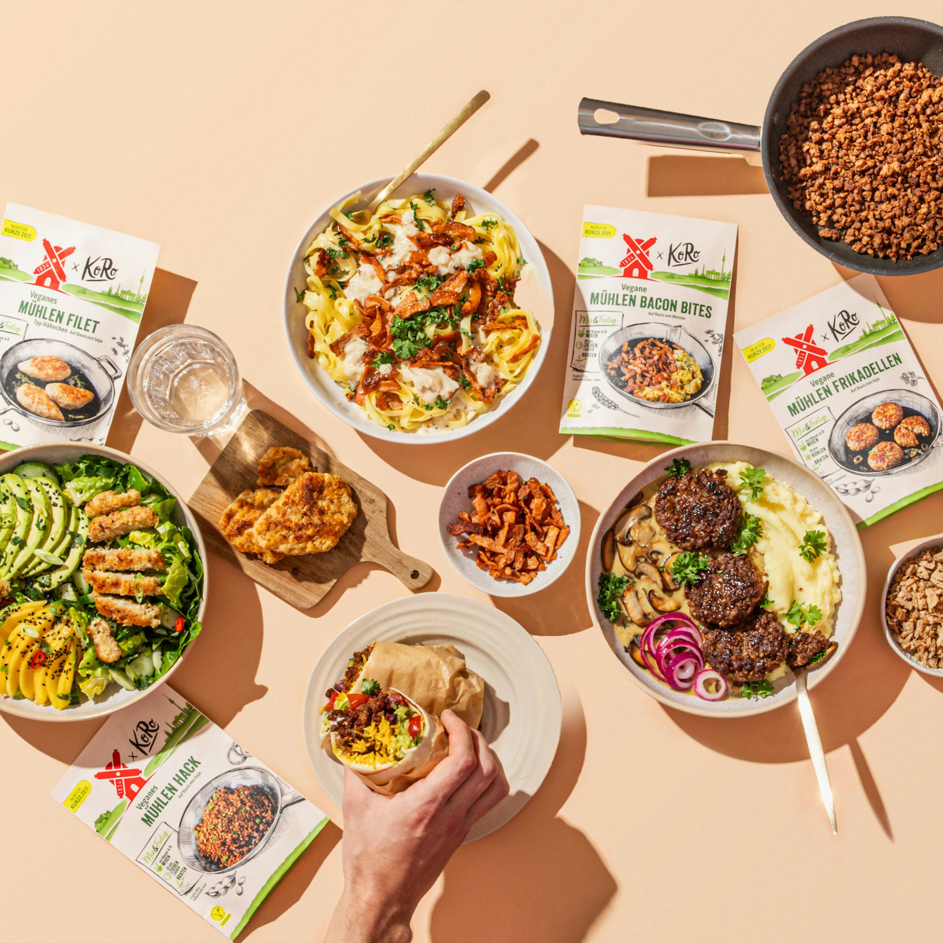 Eine Person nimmt einen Snack aus einer Schüssel mit einer Mahlzeit aus einer Reihe von Mahlzeiten