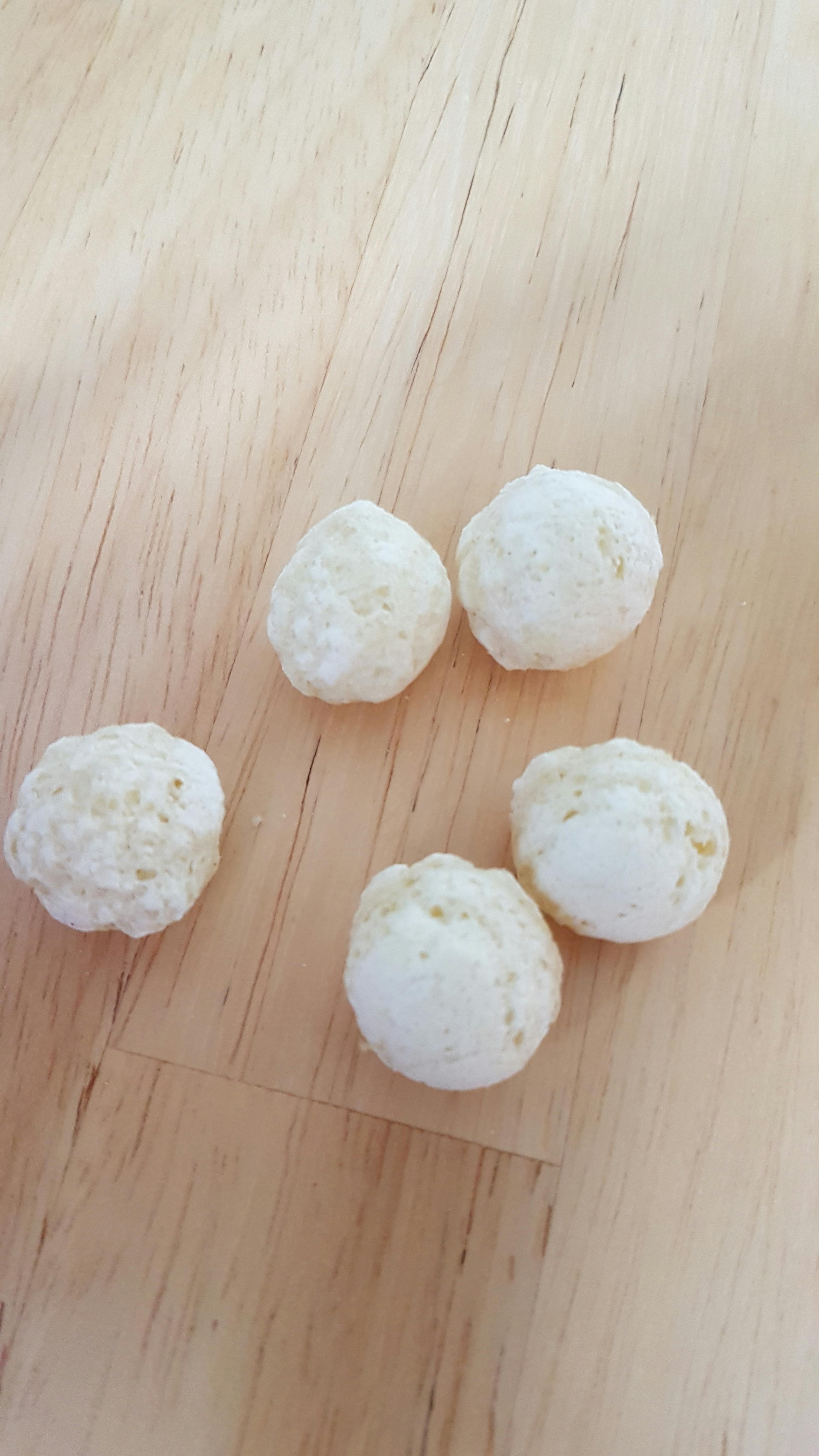 vier weiße Kugeln auf einem Holztisch