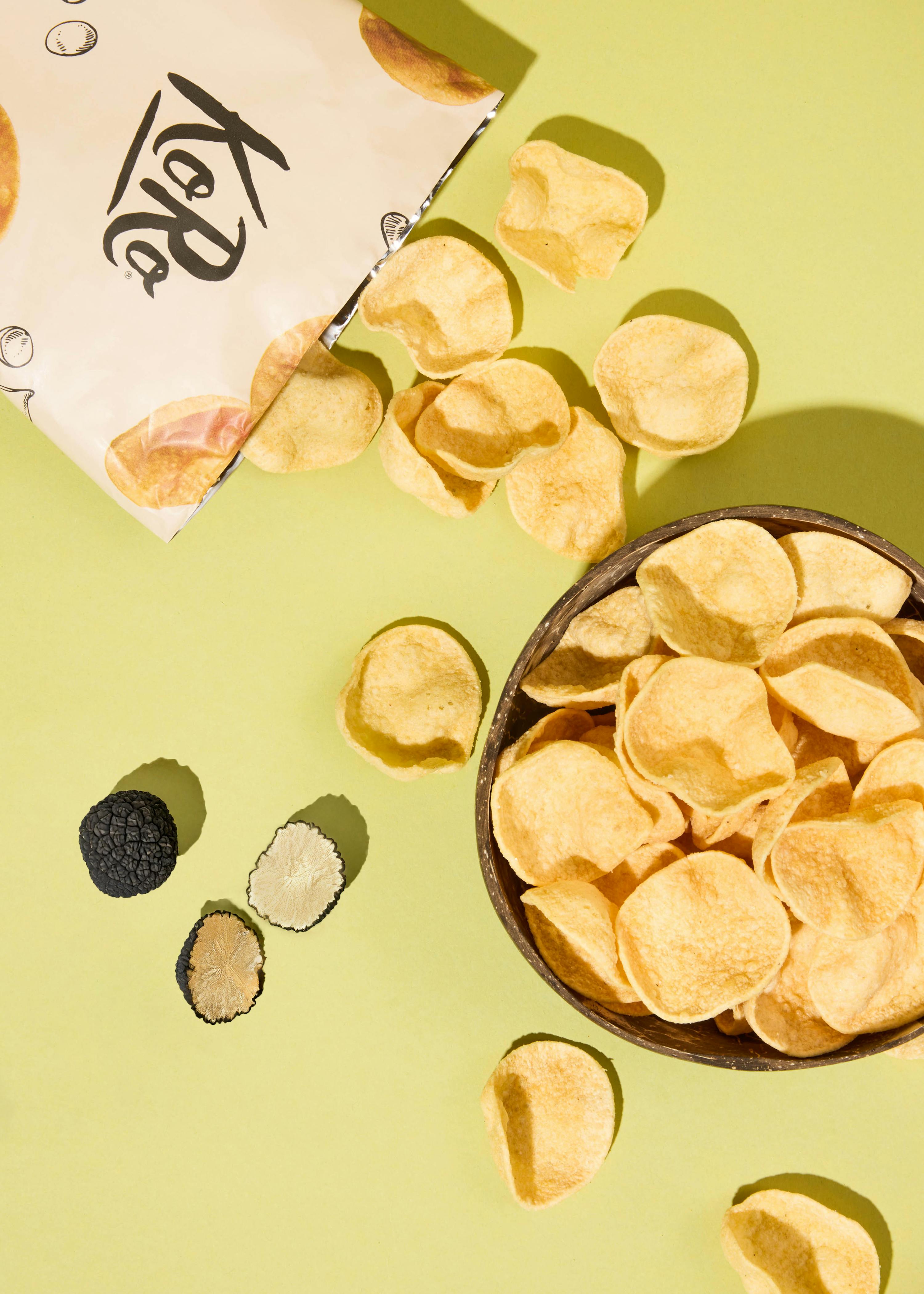 eine Tüte Kartoffelchips liegt neben einer Schüssel Kartoffelchips