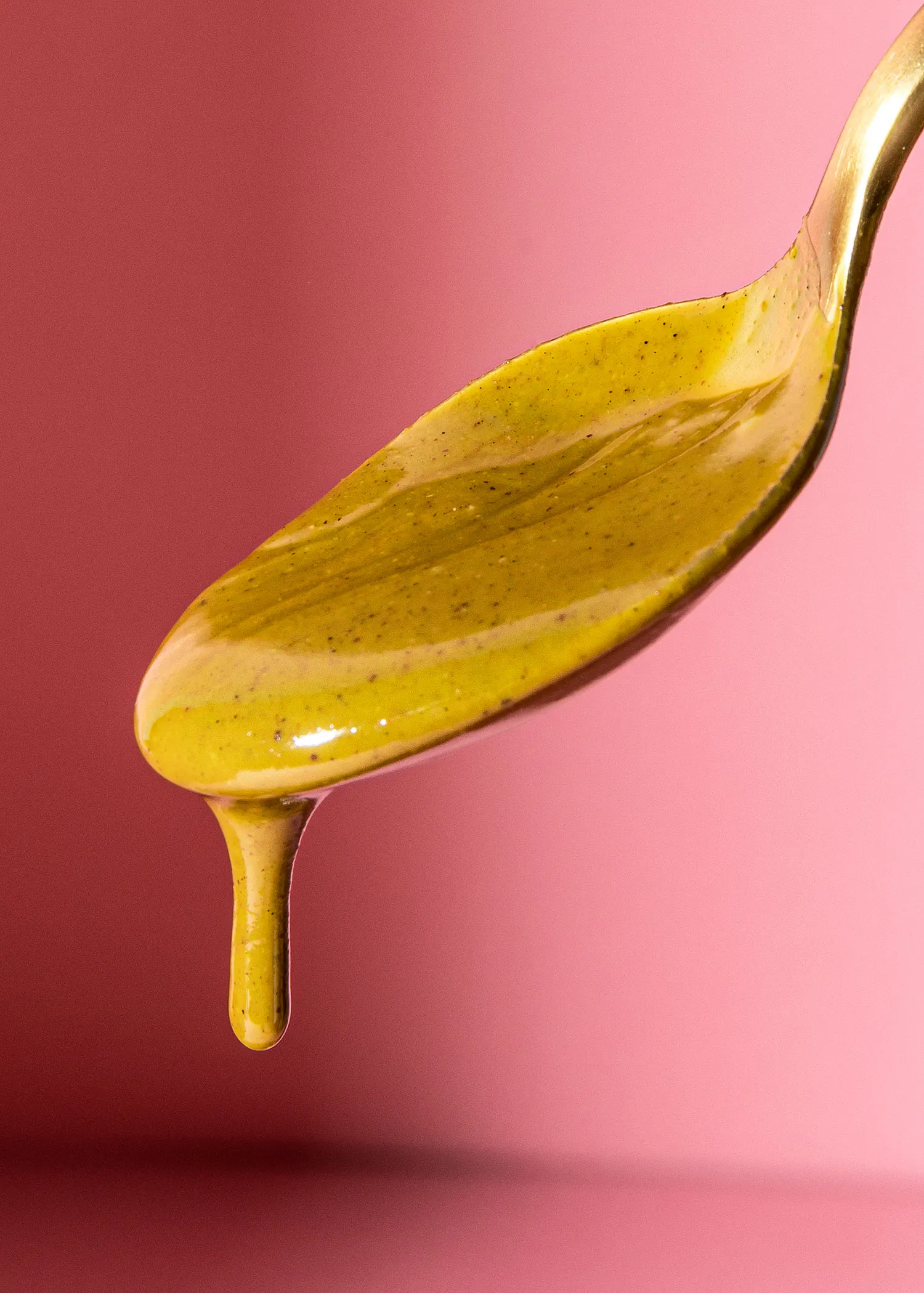 a spoon with a yellow liquid dripping from it