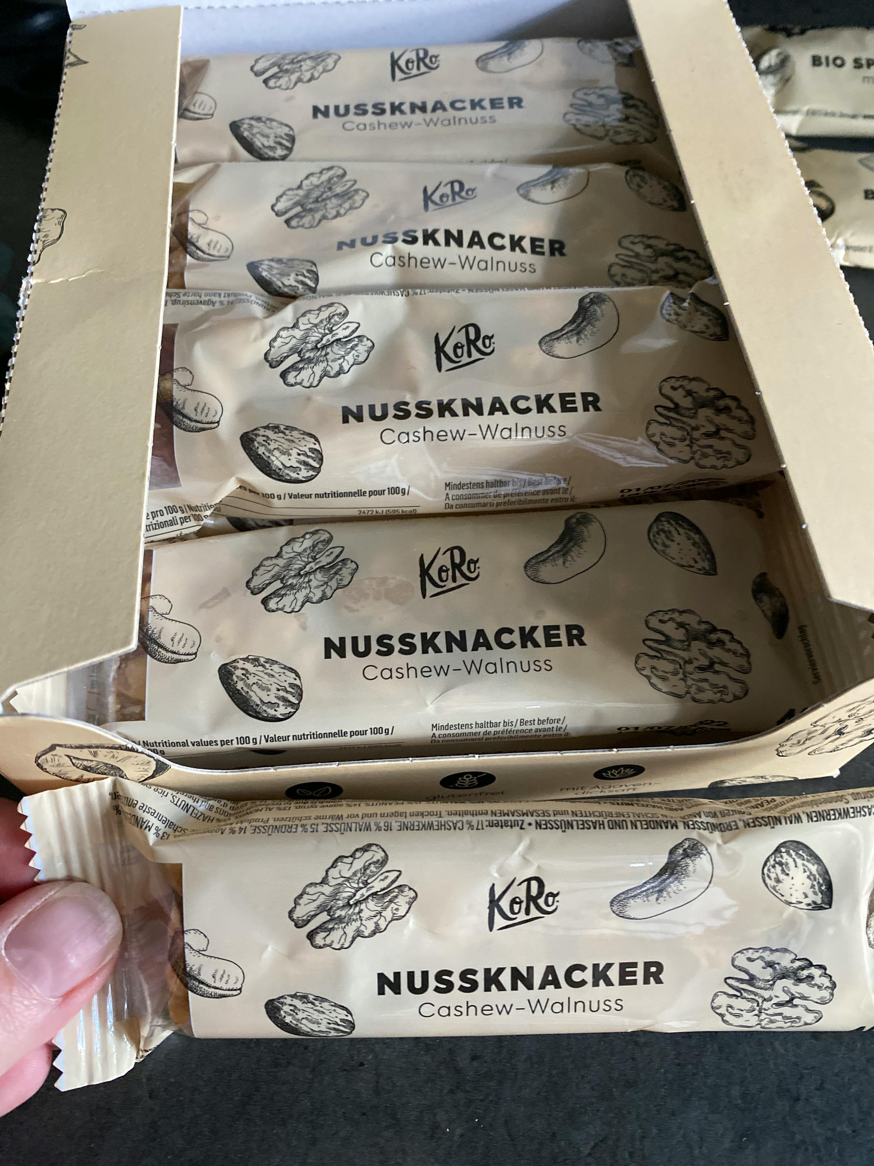 eine Person hält eine Schachtel nussknacker-cashew-walnuss-Riegel