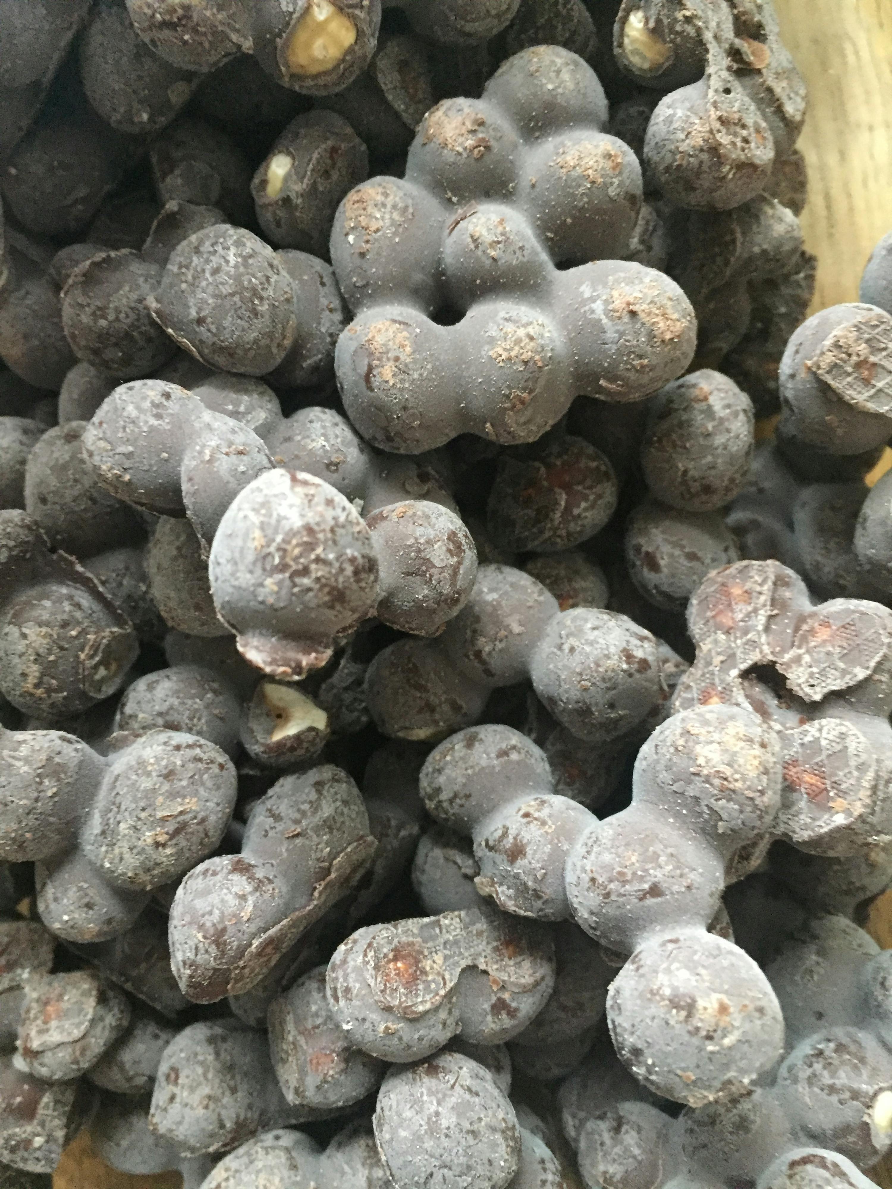 un tas de noix enrobées de chocolat sont empilées les unes sur les autres