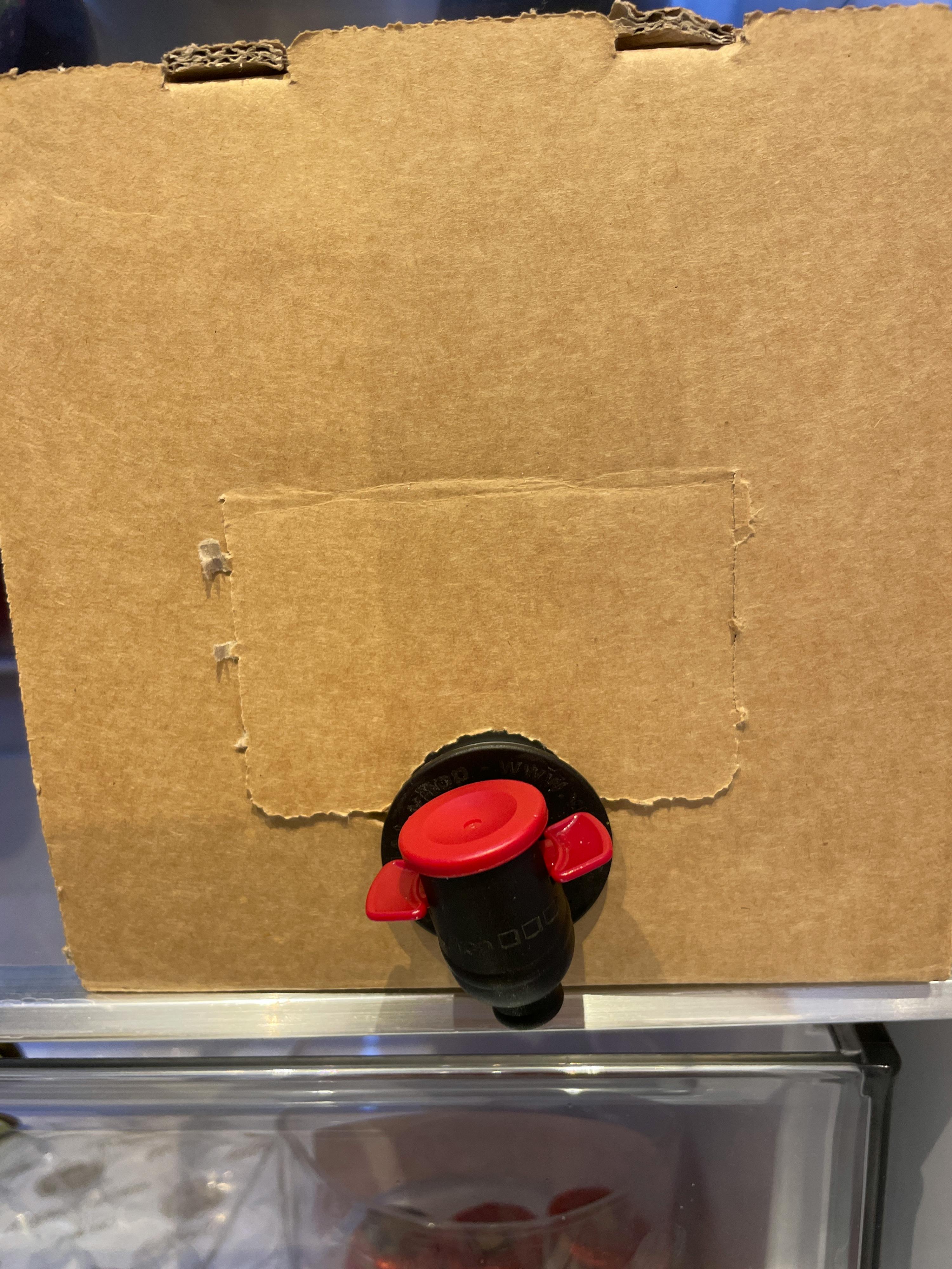 une boîte en carton marron avec une bouteille rouge à l' intérieur