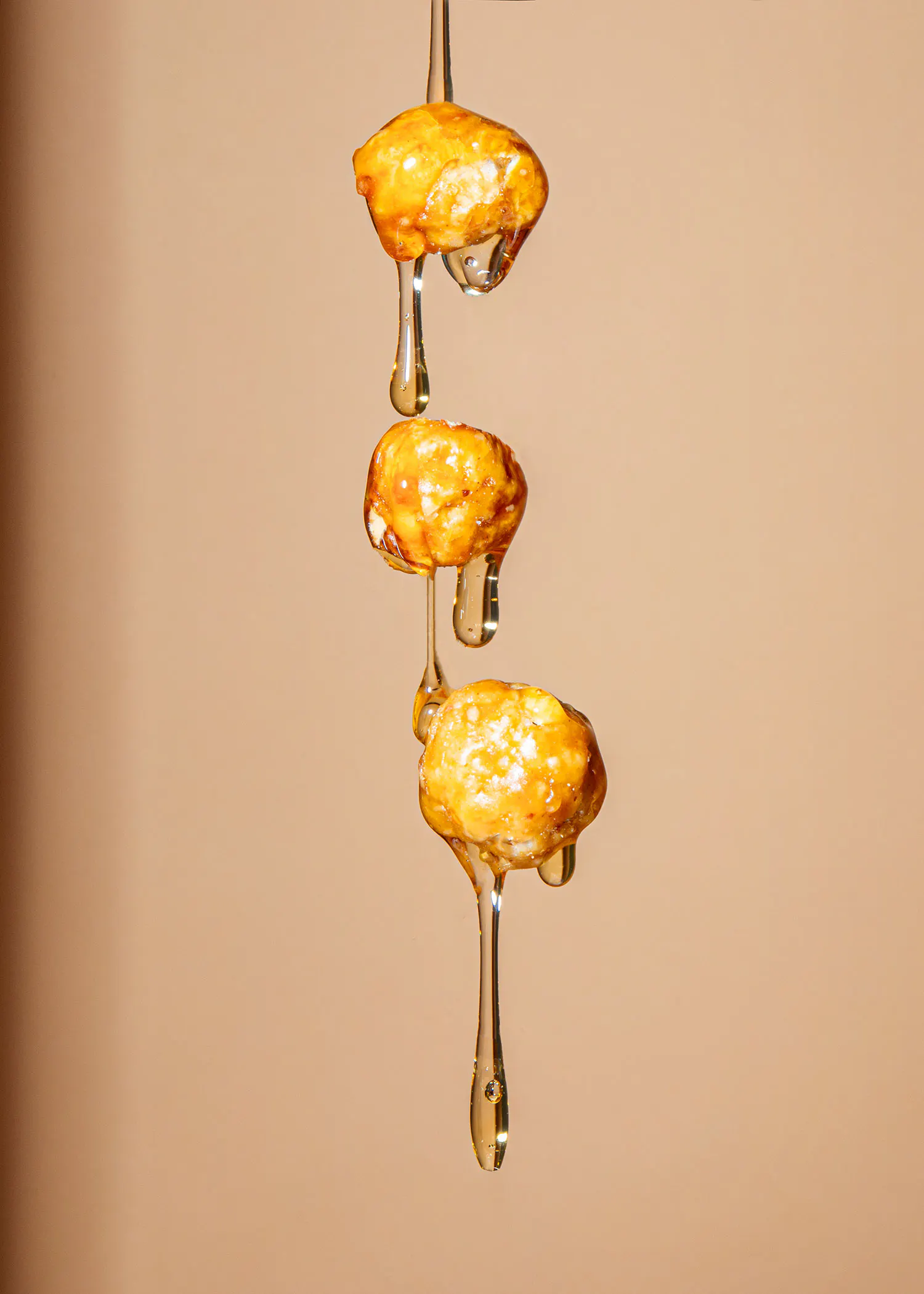 Honig läuft aus einem Löffel auf einem Popcorn