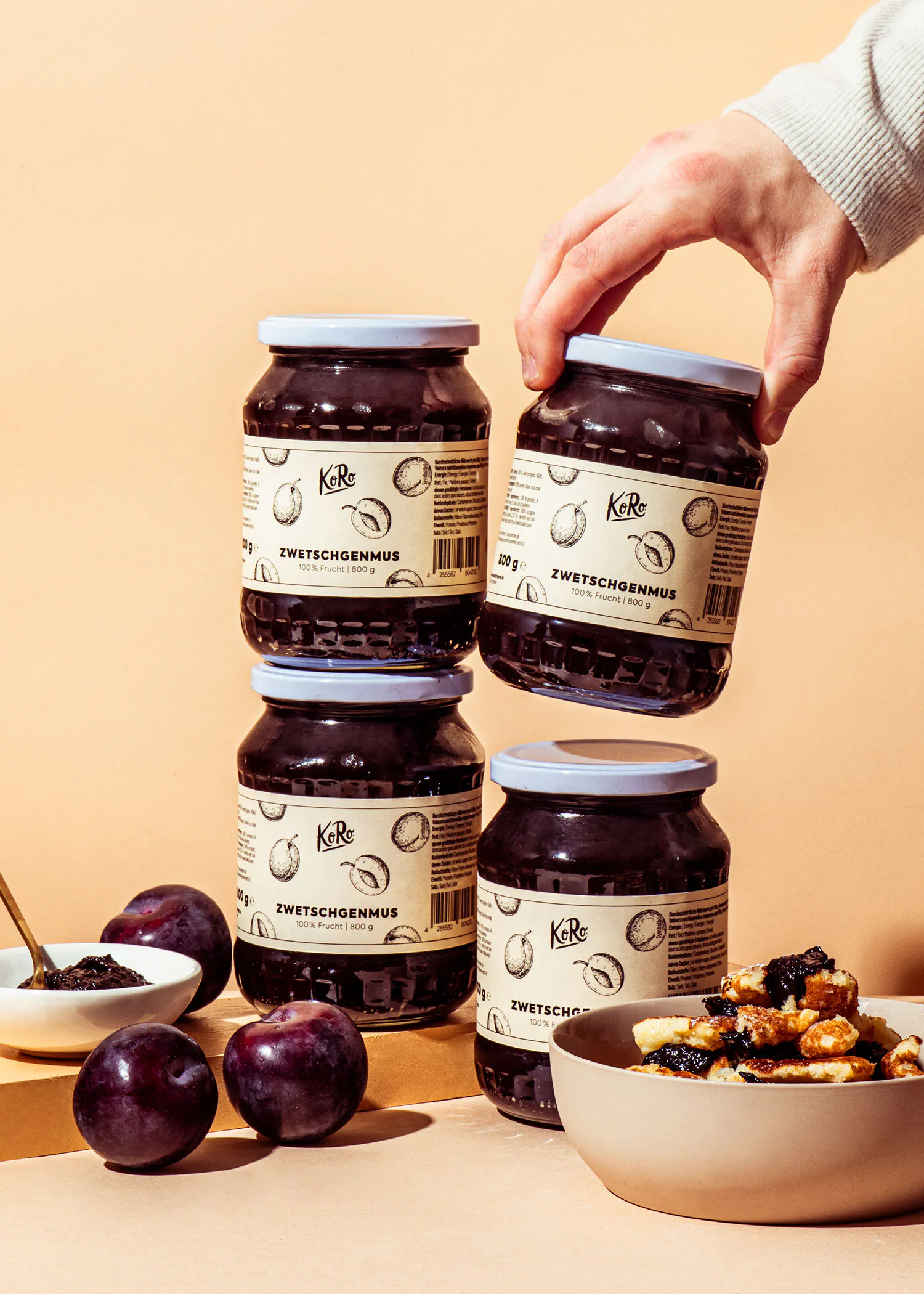 eine Person stapelt vier Gläser zweitschgenmus aufeinander