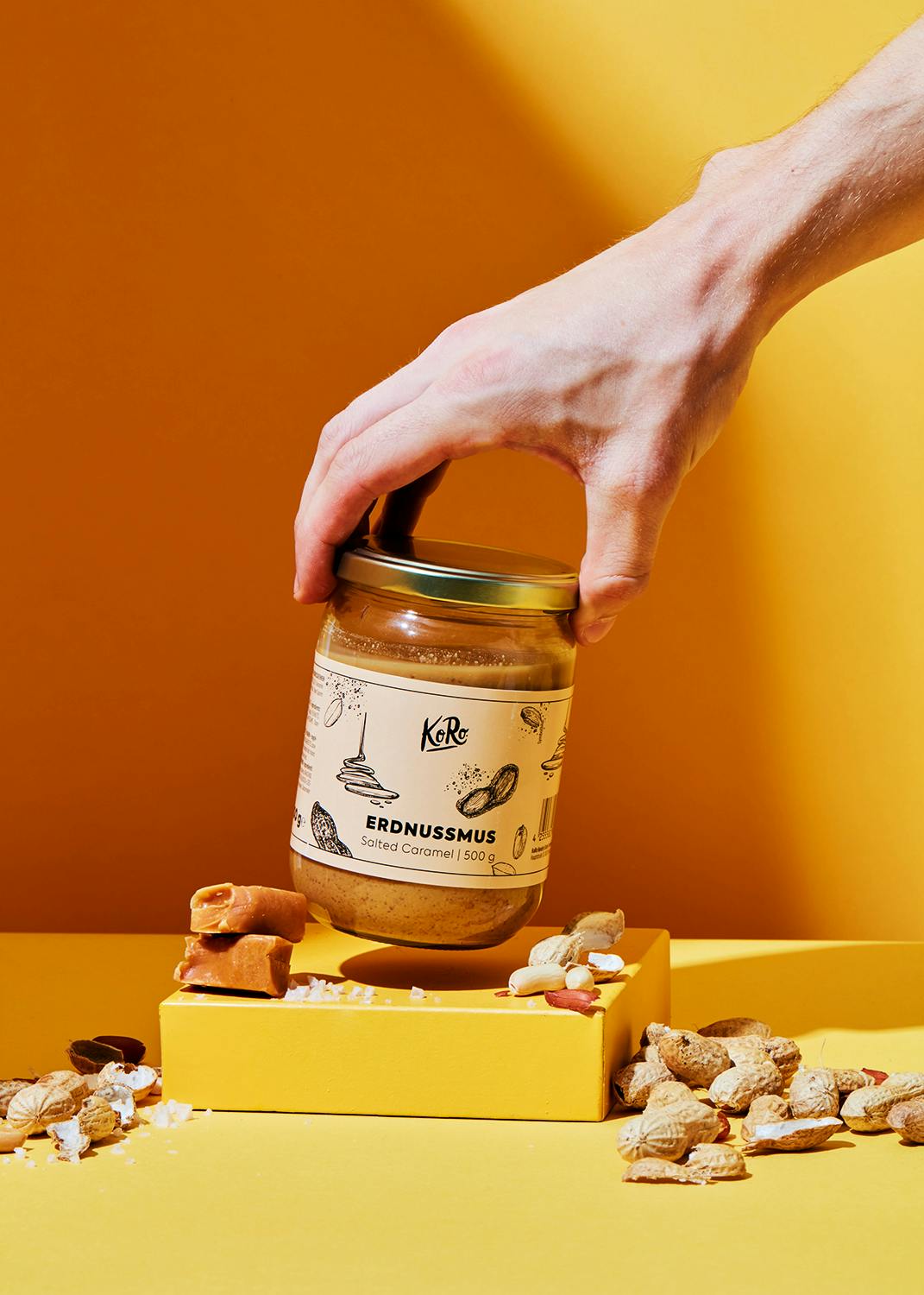 a jar of erdnussmus is being held by a hand