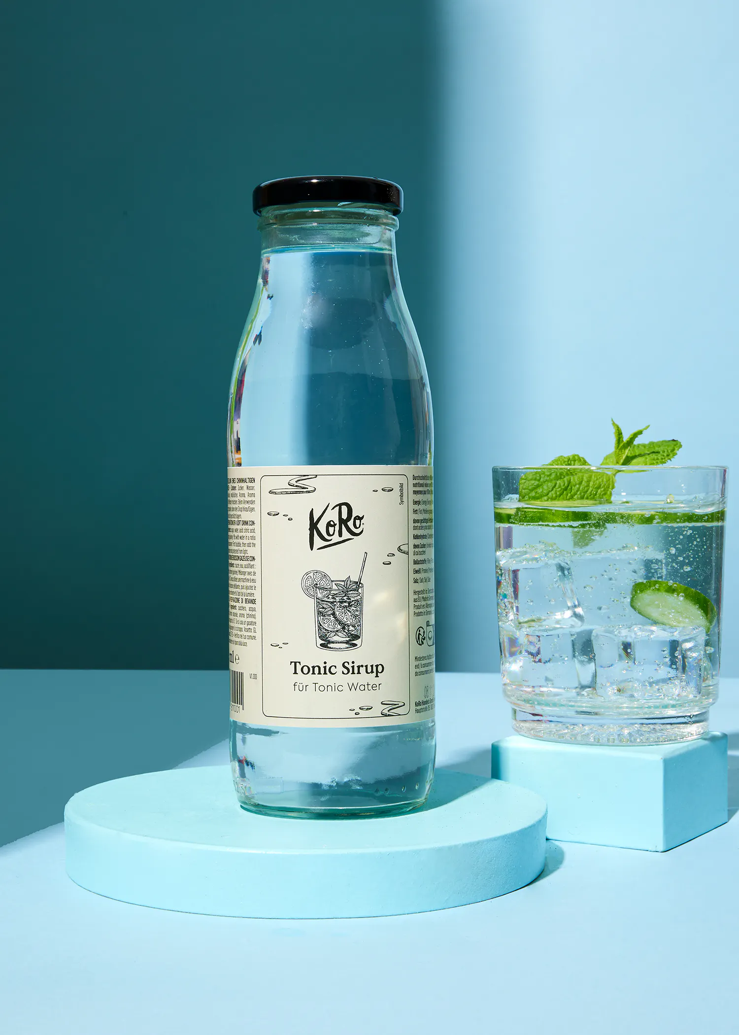 eine Flasche tonic-Syrup steht neben einem Glas mit tonic-Wasser