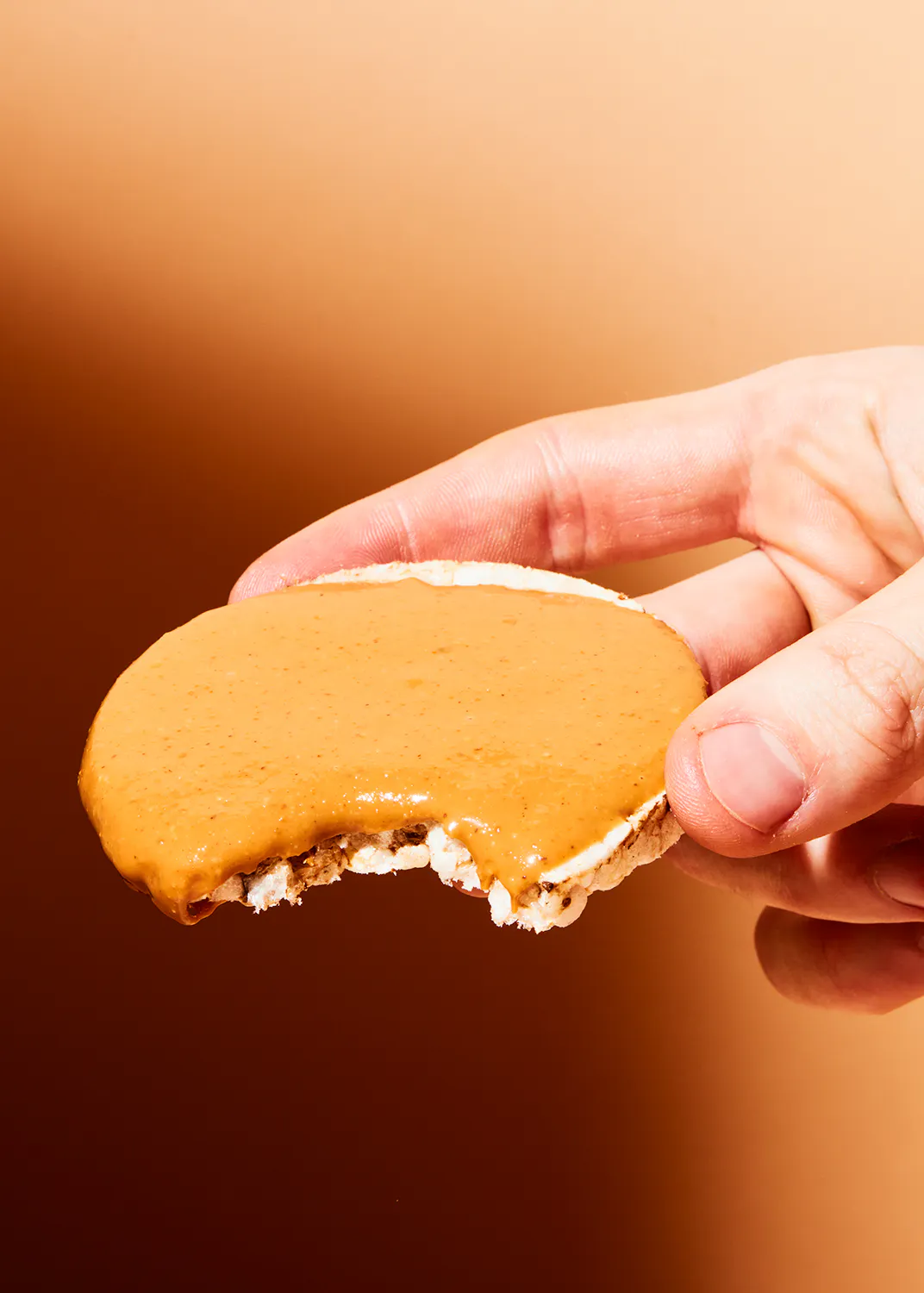 une personne tient un biscuit au beurre d' arachide avec une bouchée prise