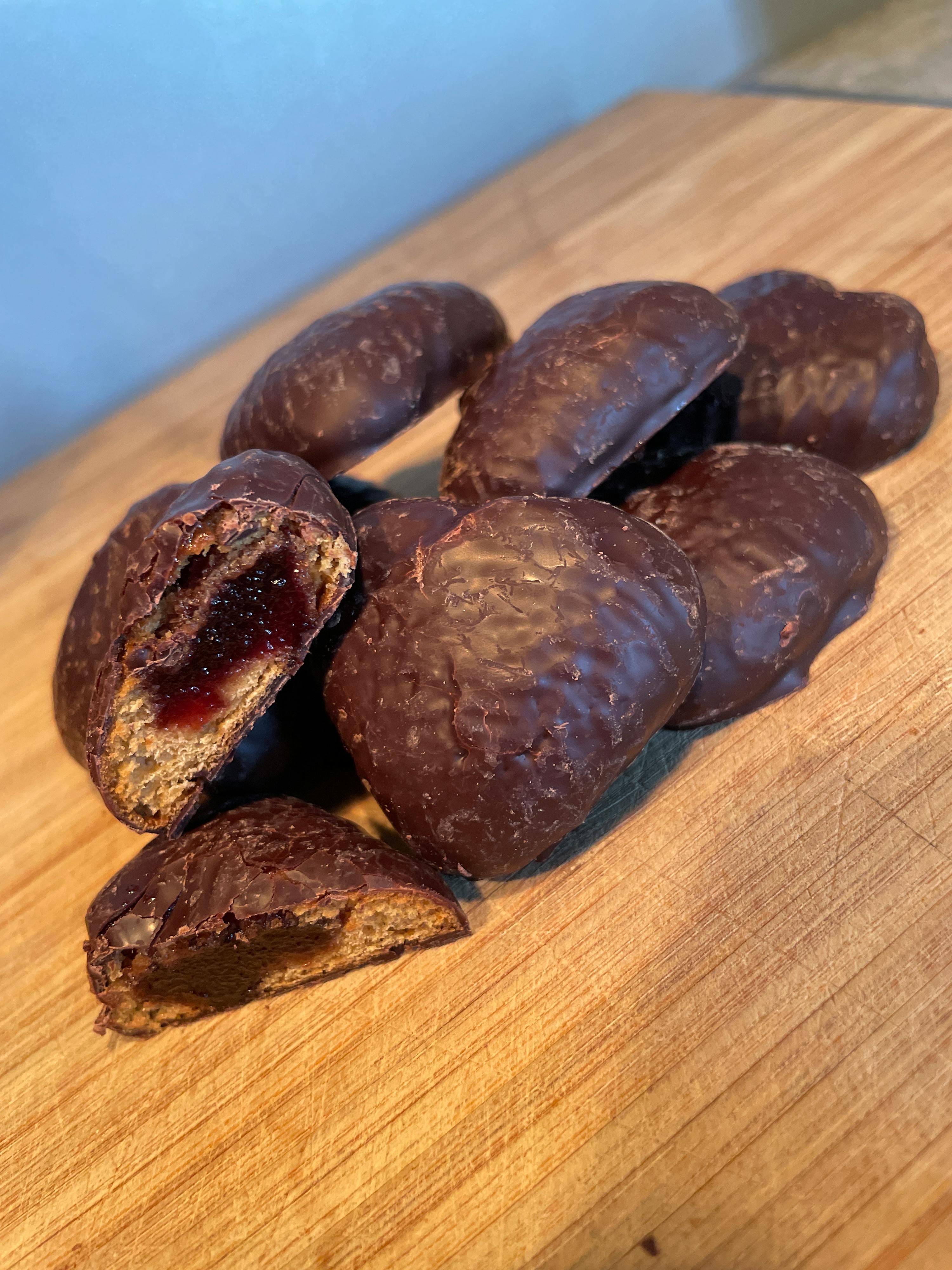a bunch of chocolate covered cookies on a cutting board