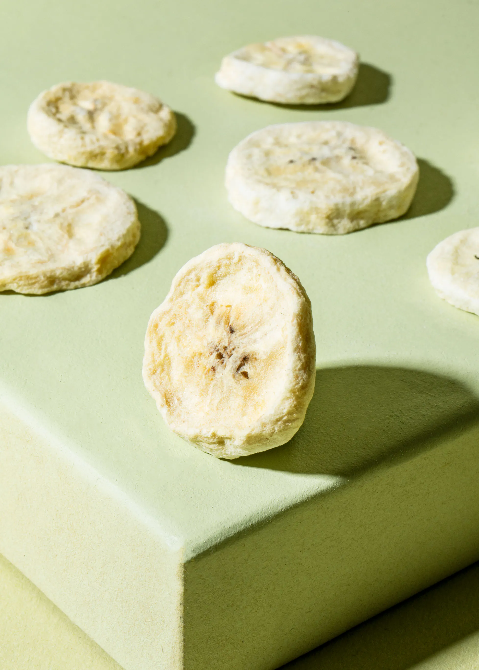 a bunch of banana chips are sitting on a green surface