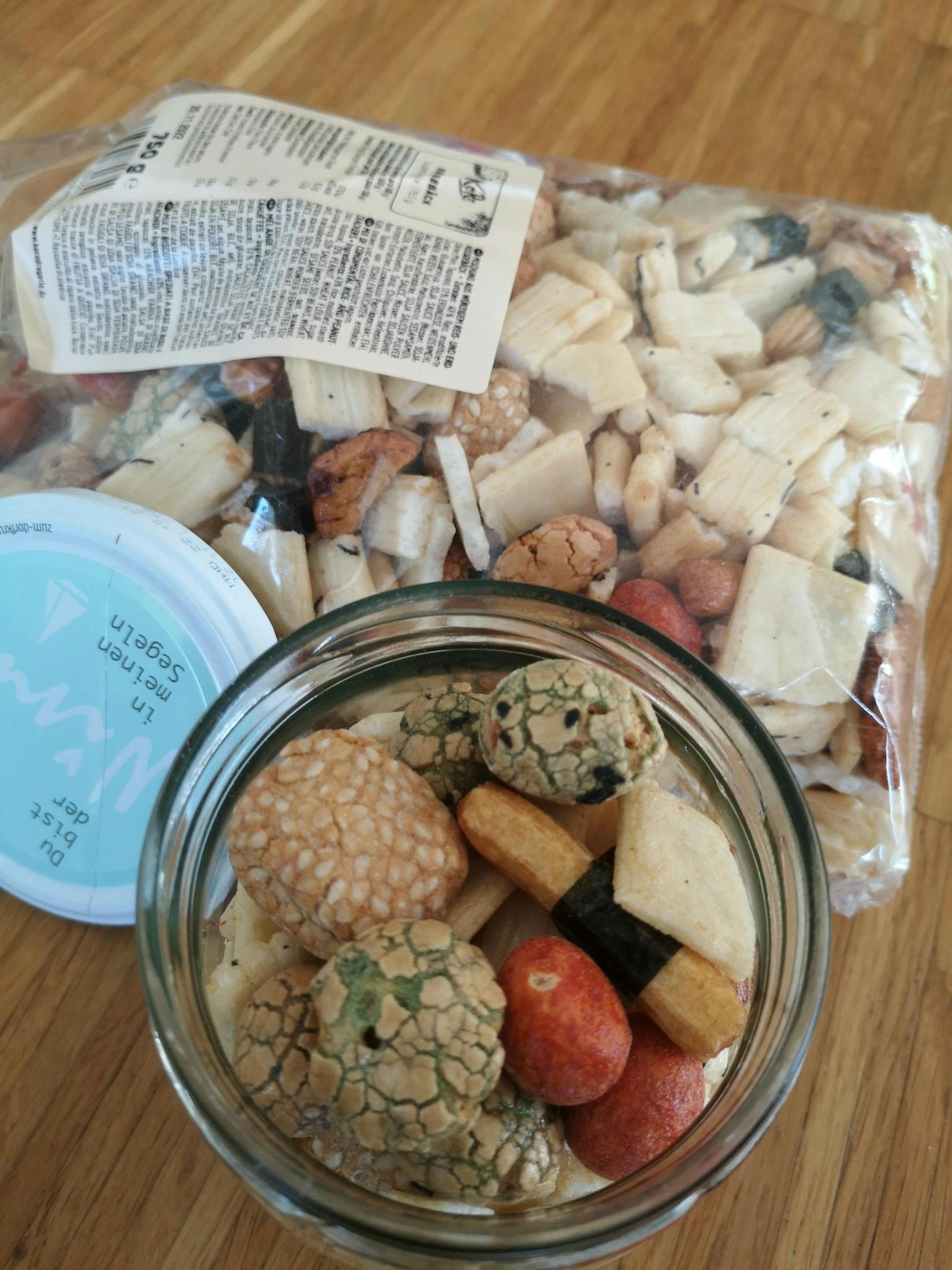 un barattolo di frutta secca è seduto accanto a un sacchetto di frutta secca