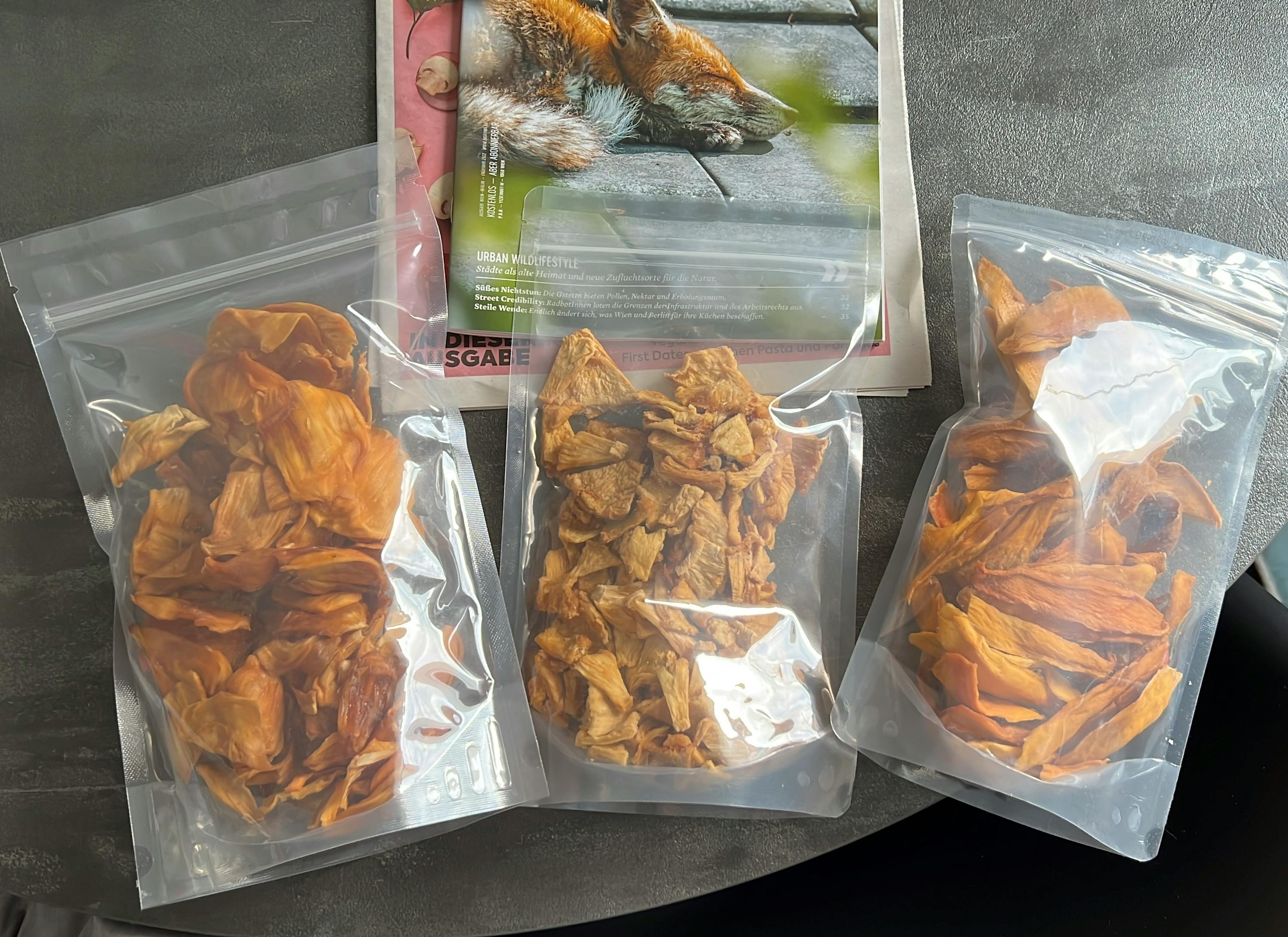 tre sacchetti di cibo sono seduti su un tavolo accanto a un giornale con una volpe su di esso