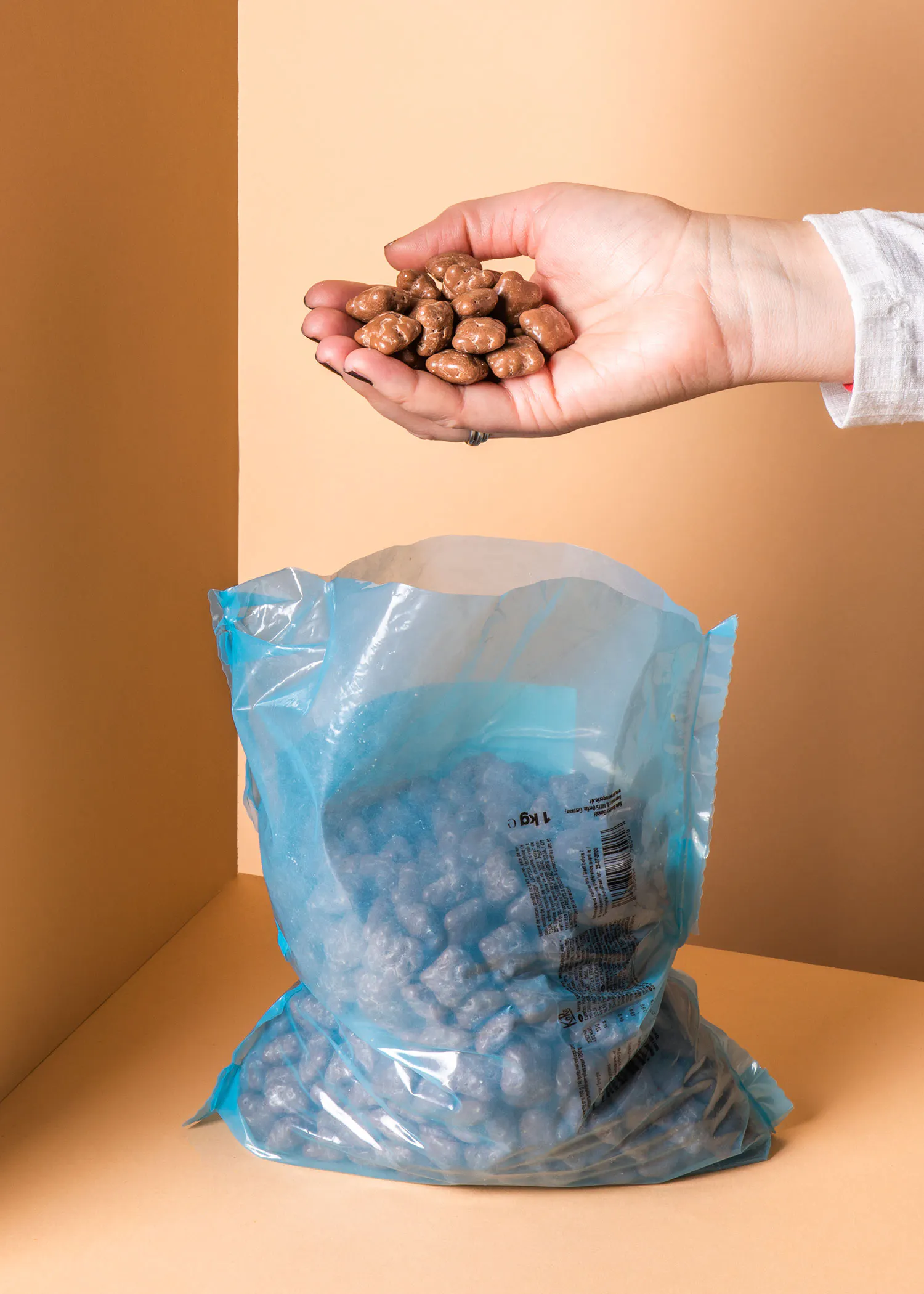 une personne tient un tas d' amandes au chocolat dans sa main