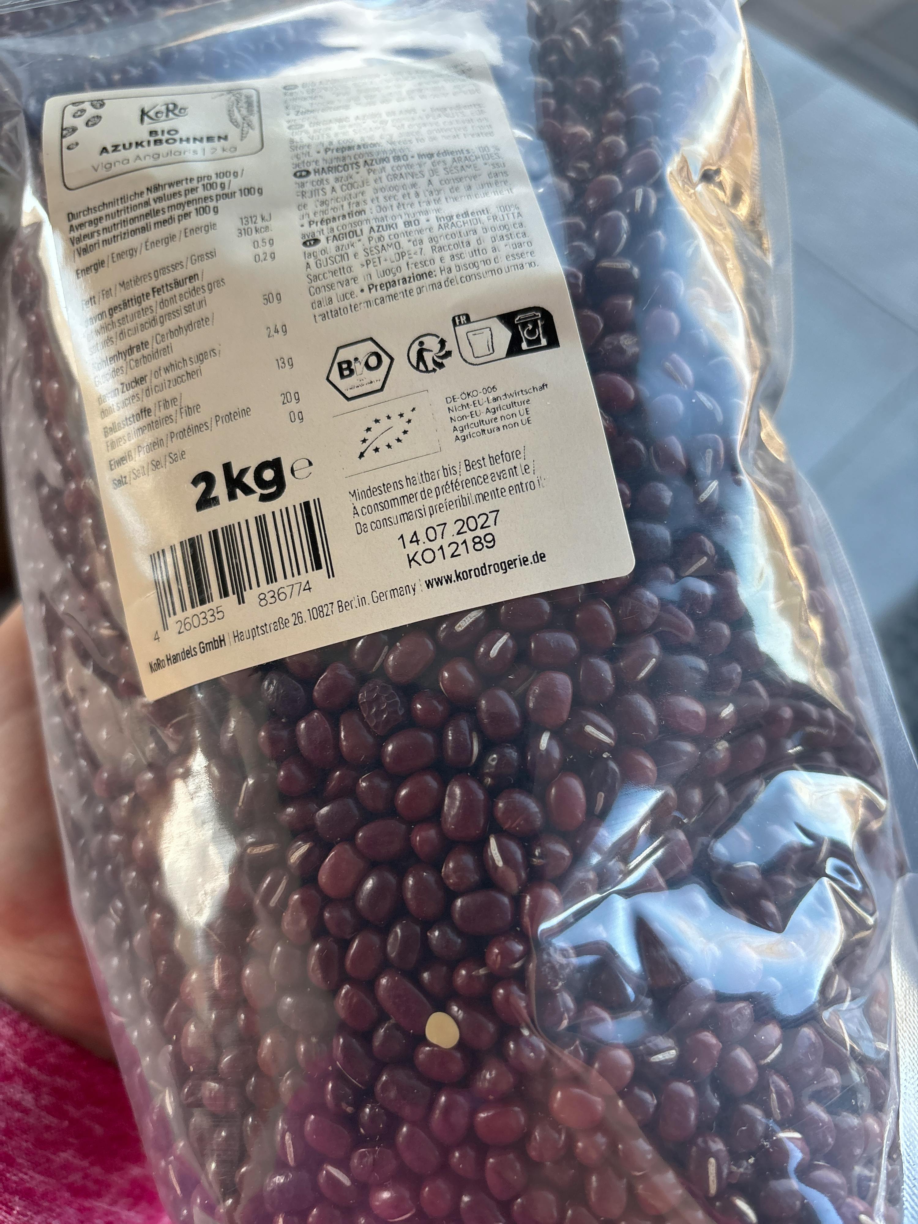 un sac en plastique transparent de 2 kg de haricots azuki bio koro avec une étiquette affichant les informations nutritionnelles et une date de péremption du 14.07.2027.