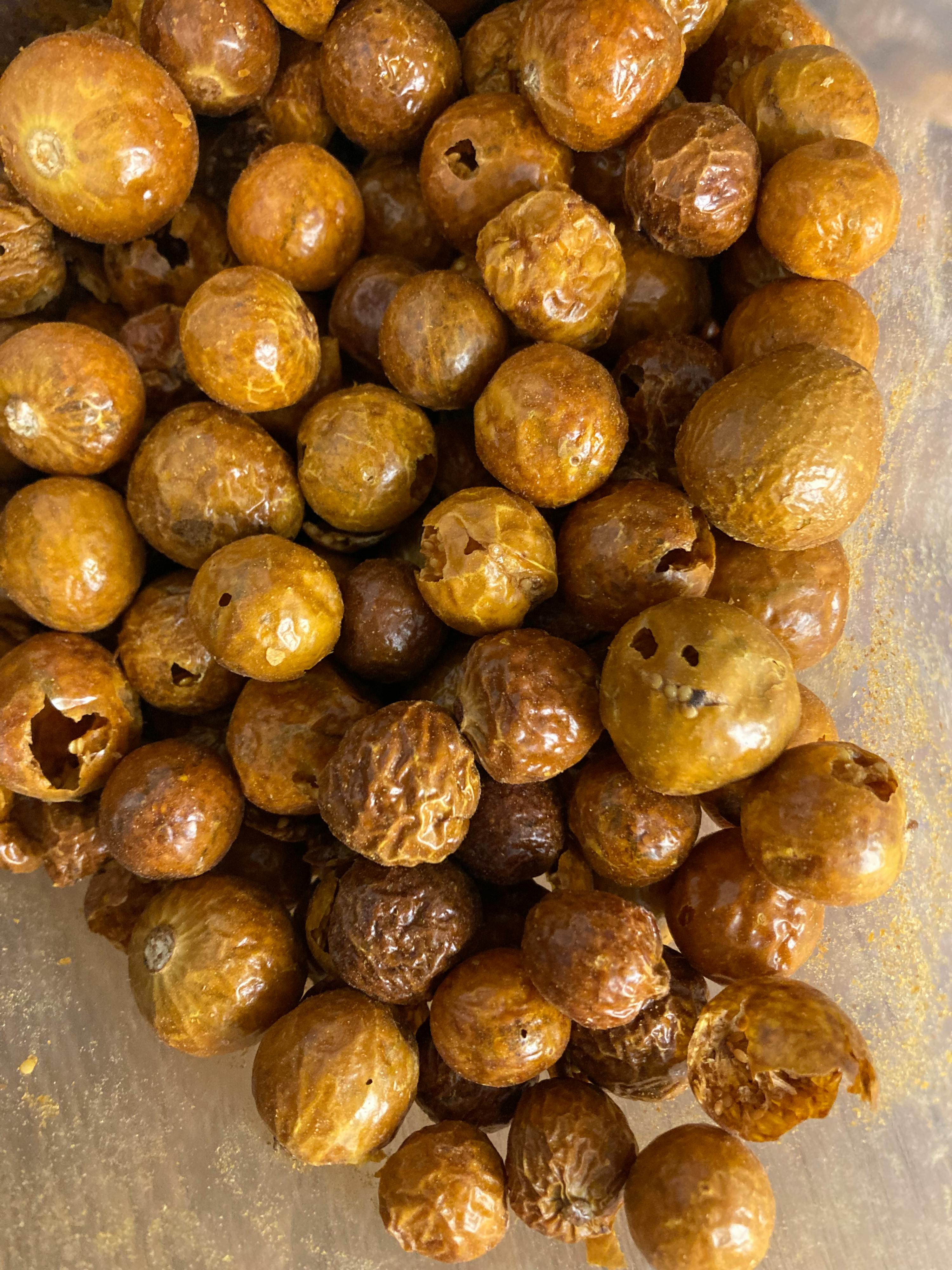 ein Haufen brauner Nüsse mit Löchern im Inneren