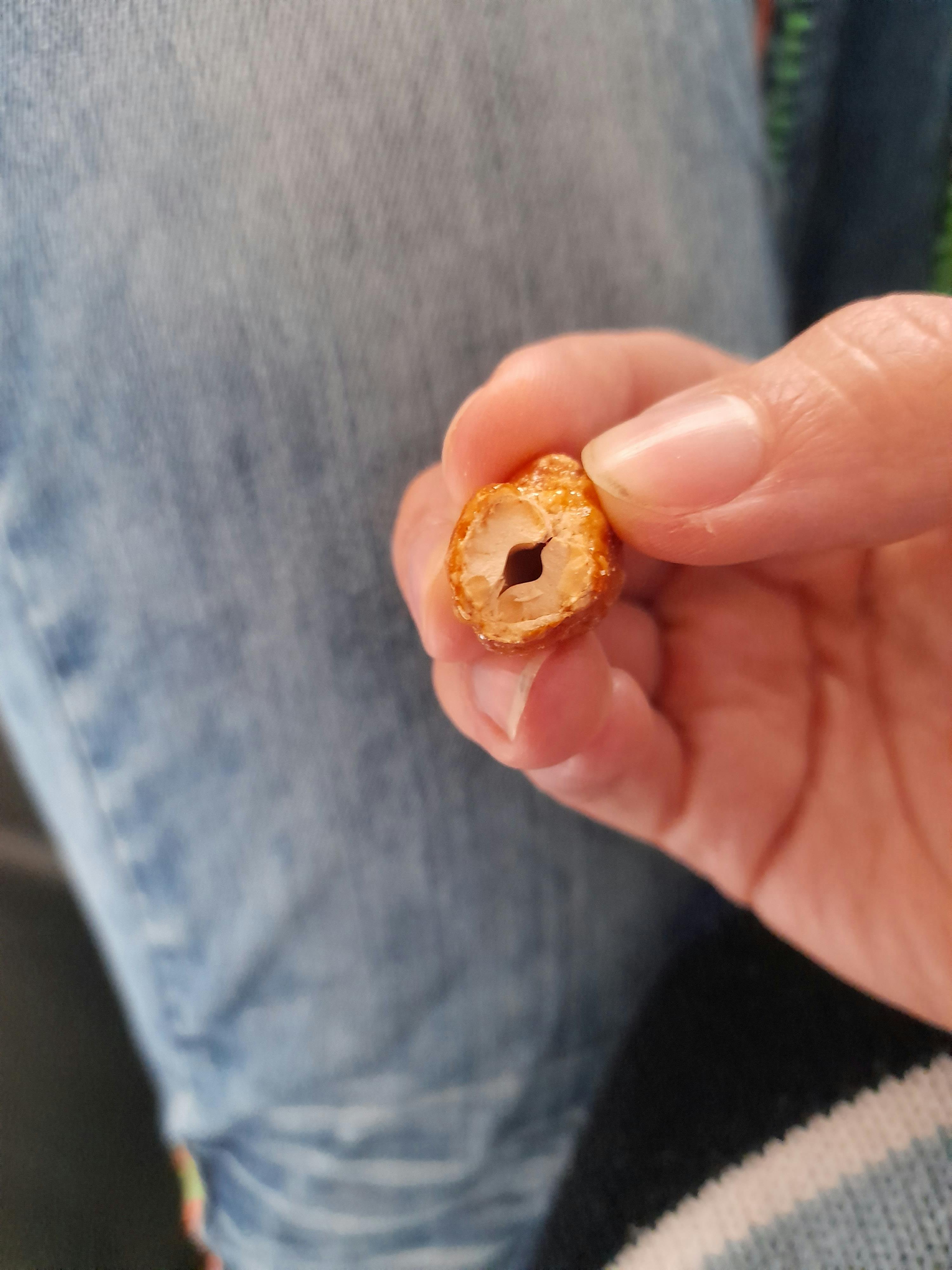 a person holding a piece of food with a hole in it