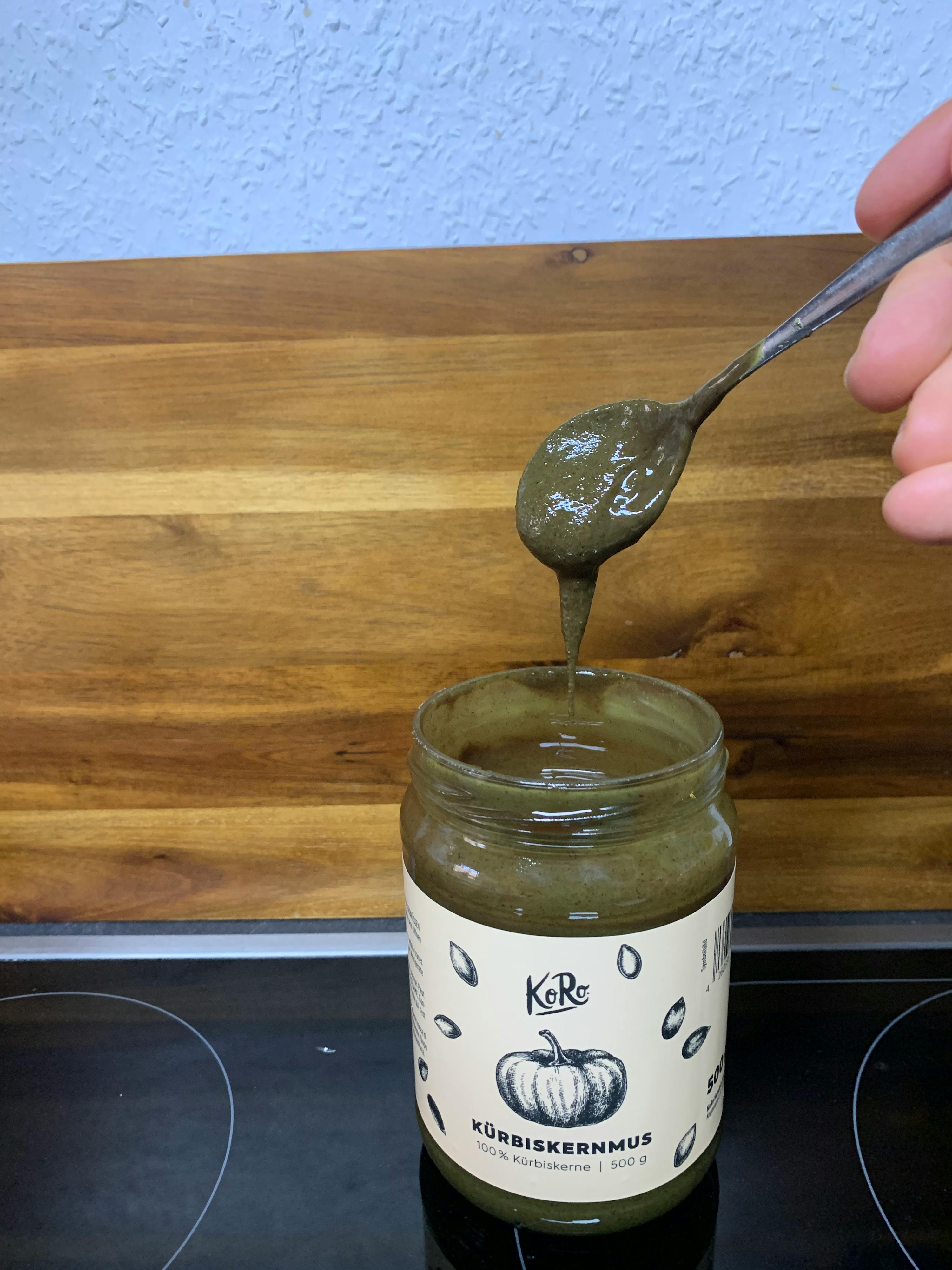 a spoon is being poured into a jar of pumpkin spread