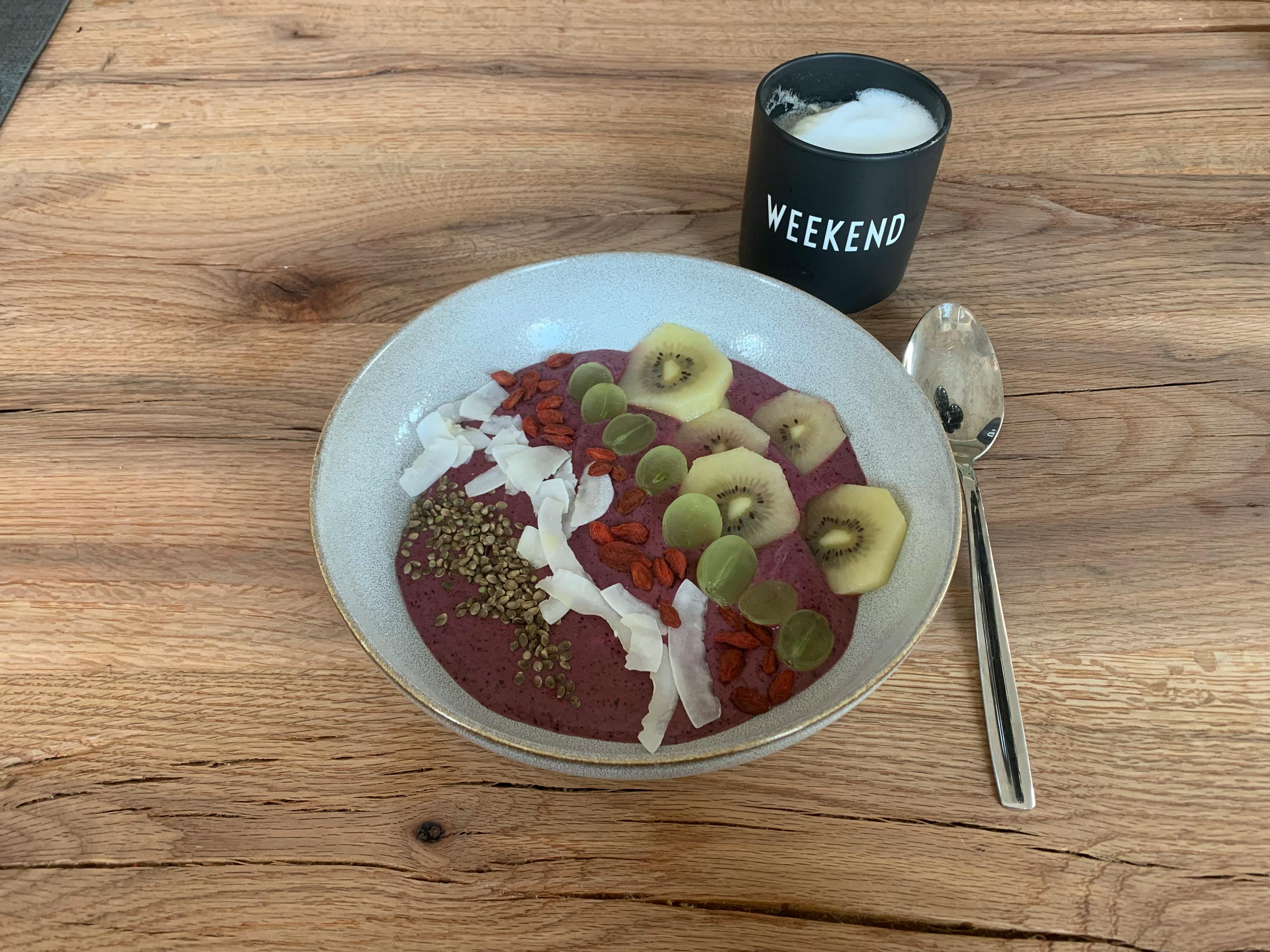 a bowl of smoothie next to a cup that says weekend