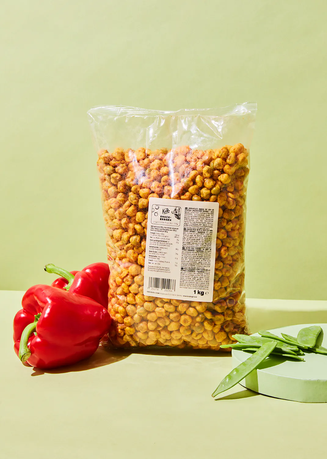 a bag of chickpeas sits next to a red pepper and green beans