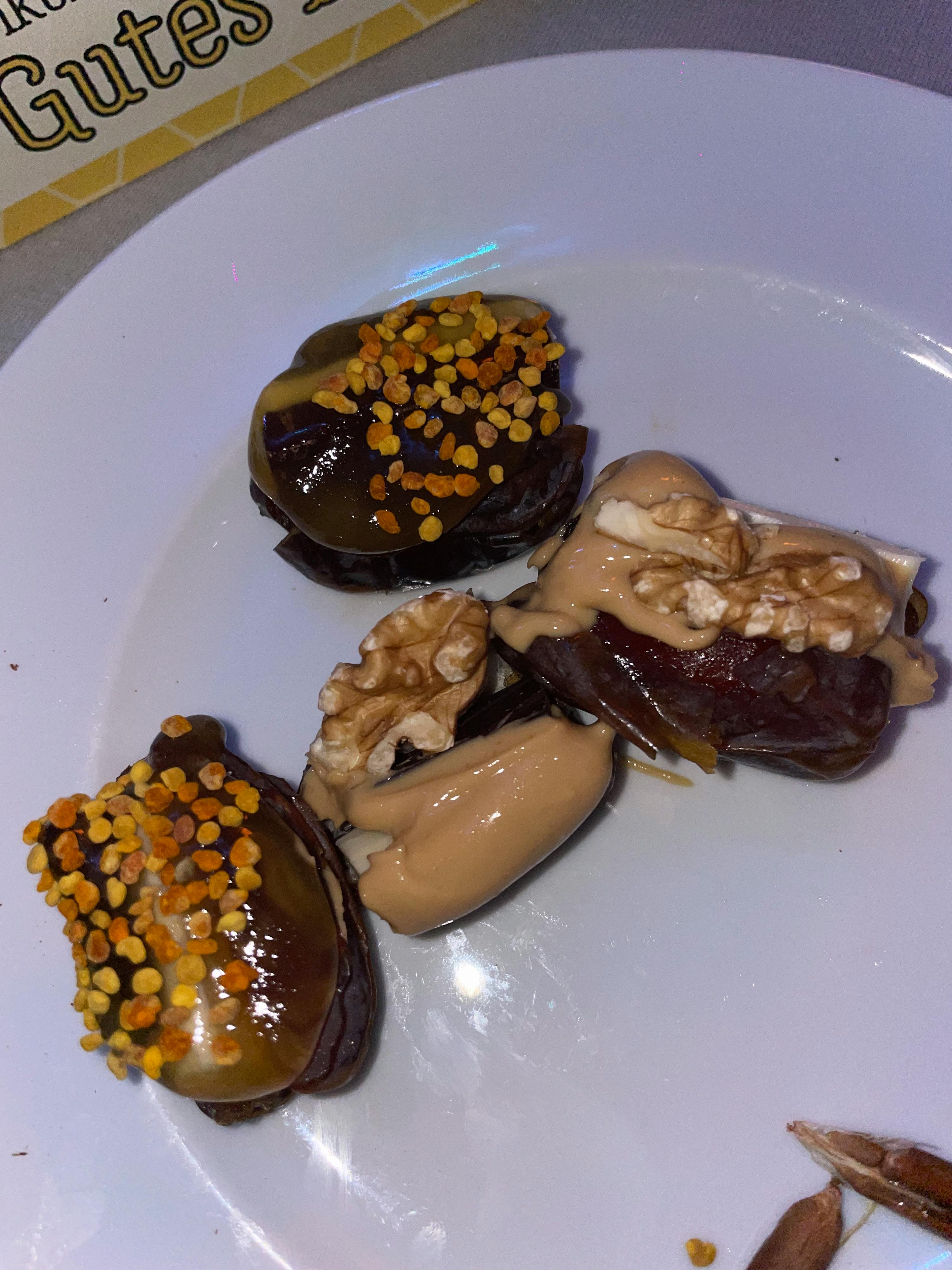 ein weißer Teller mit Desserts und einem Schild mit der Aufschrift " nuts "