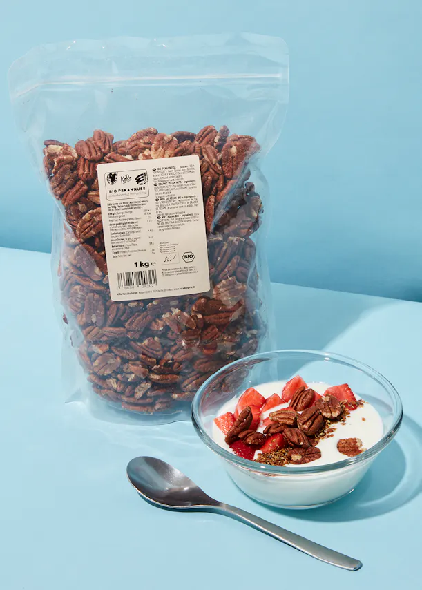 a bag of pecans sits next to a bowl of yogurt