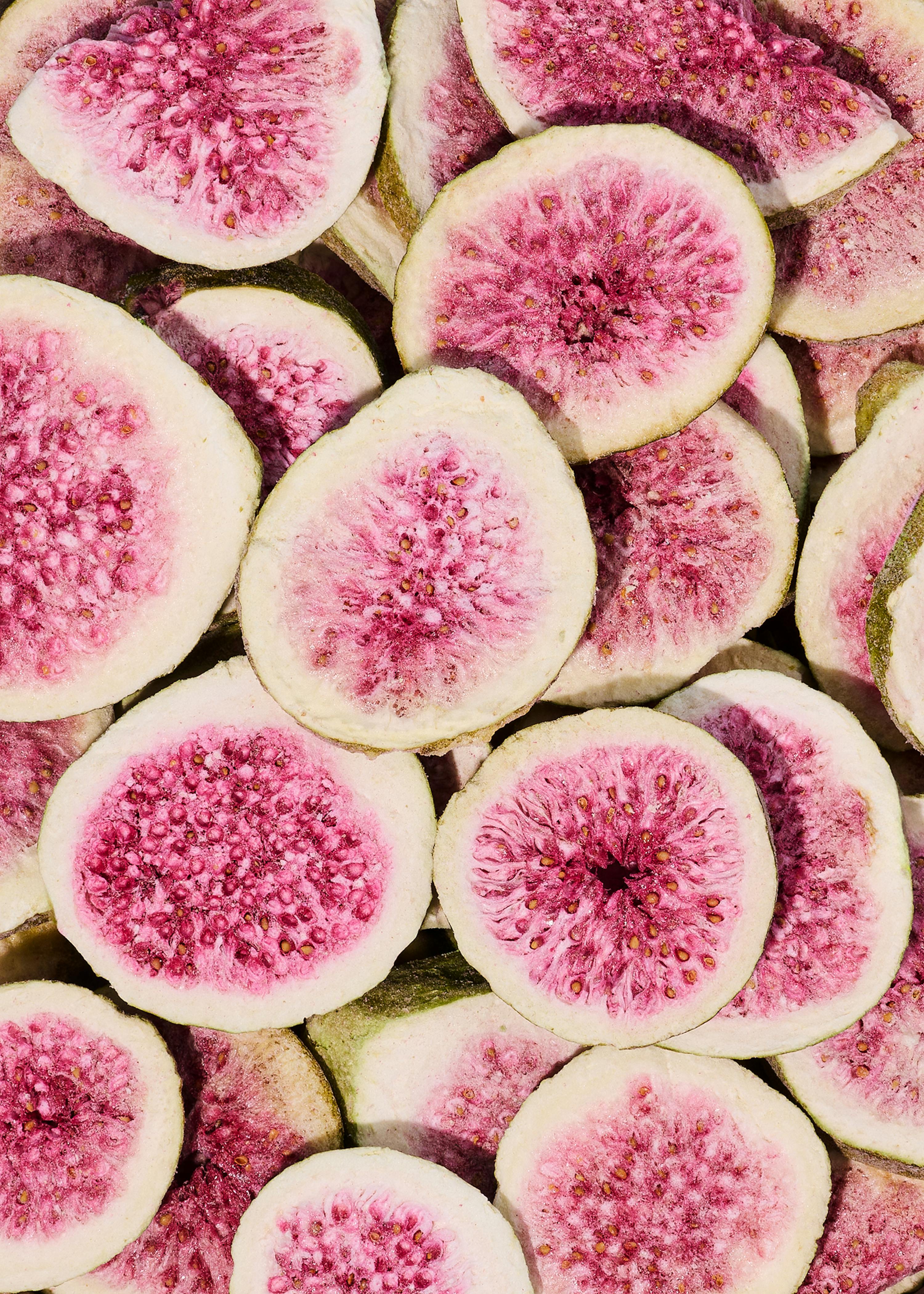 a pile of sliced figs with pink spots on them