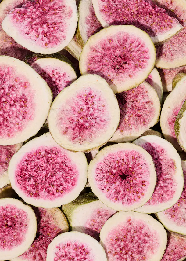 a pile of sliced figs with pink spots on them