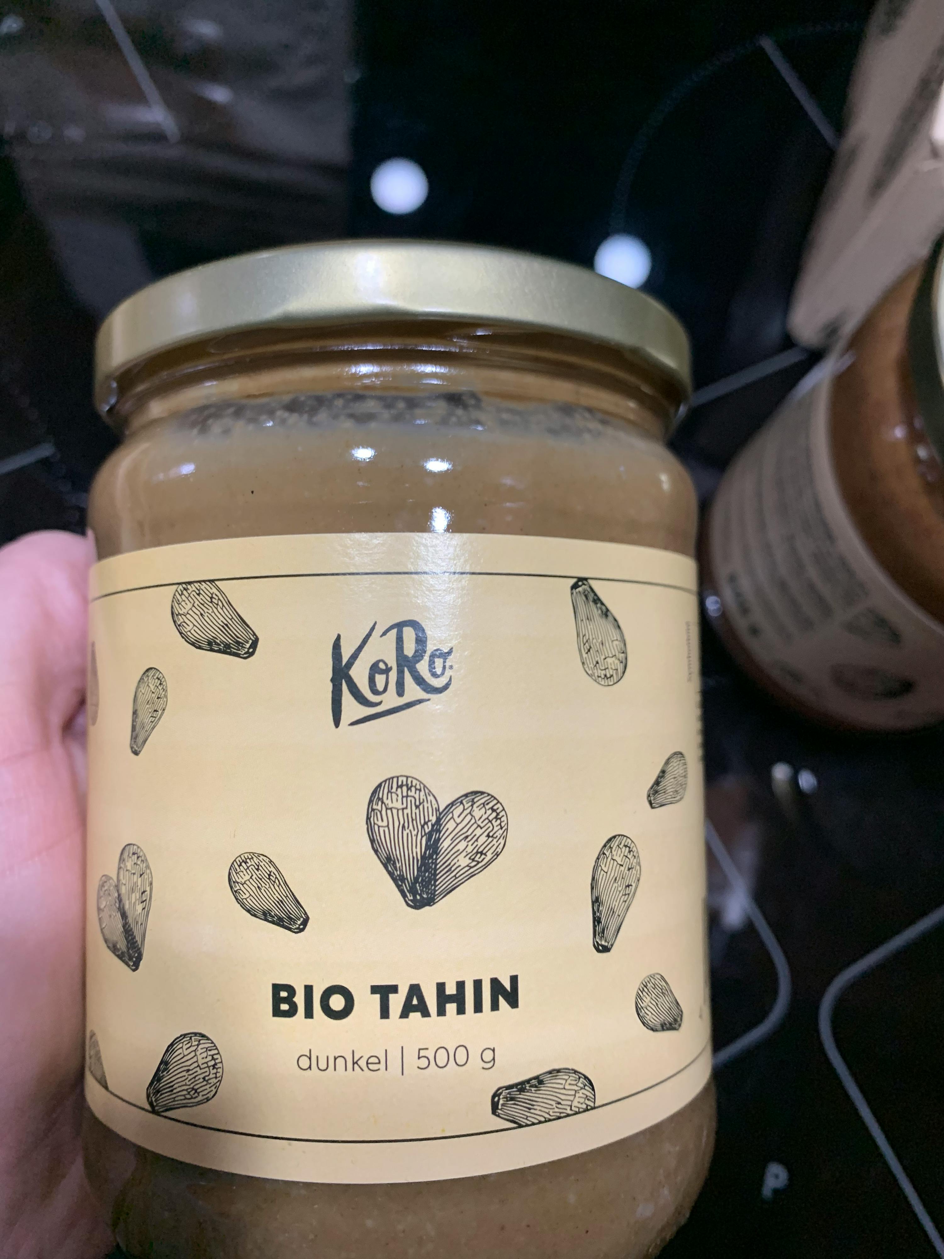 a jar of bio tahin is being held in someone 's hand